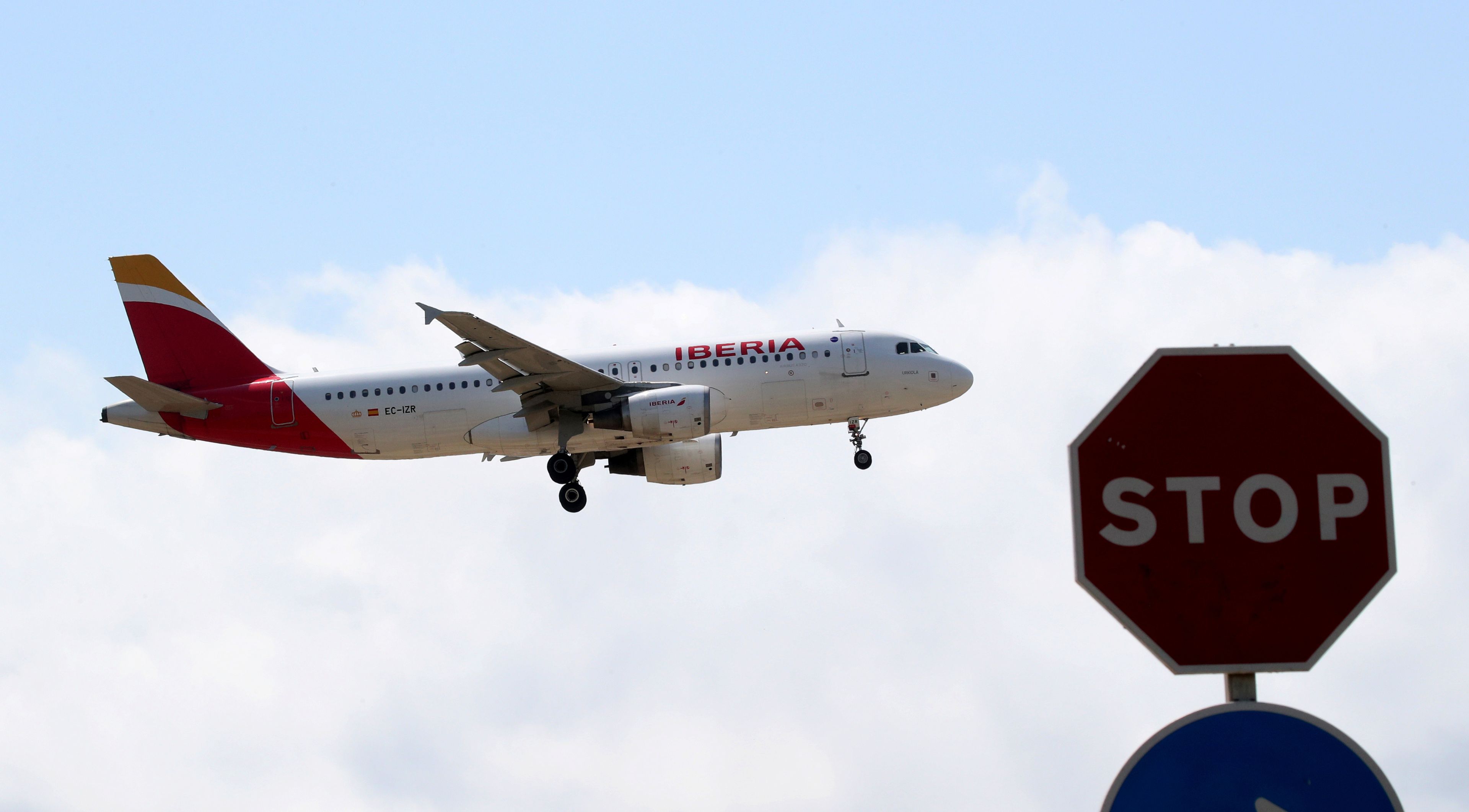 Un avión de Iberia vuela sobre el aeropuerto de El Prat de Barcelona.