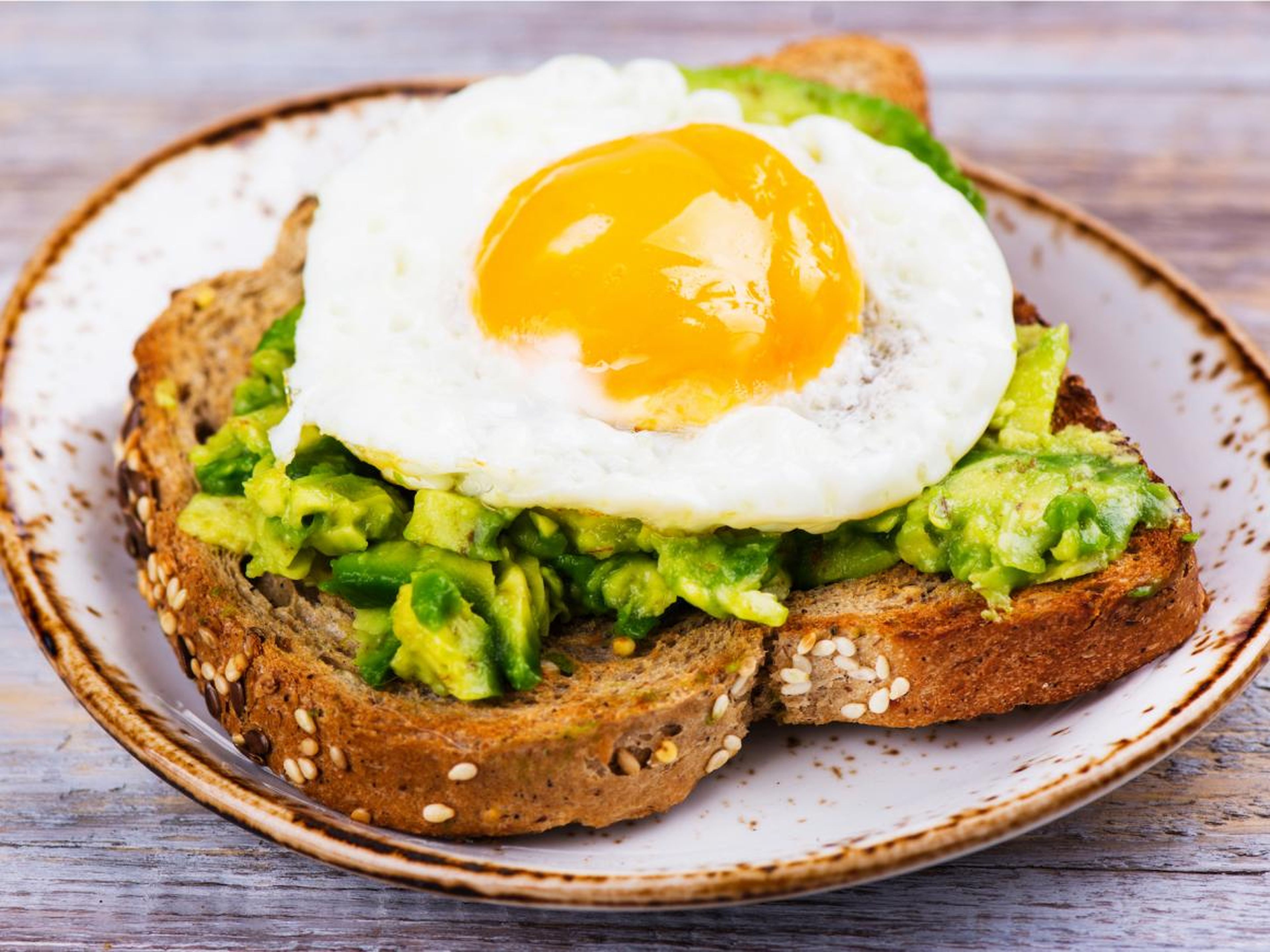 Las tostadas de aguacate cubiertas con huevo añaden grasas saludables y proteínas a una comida.
