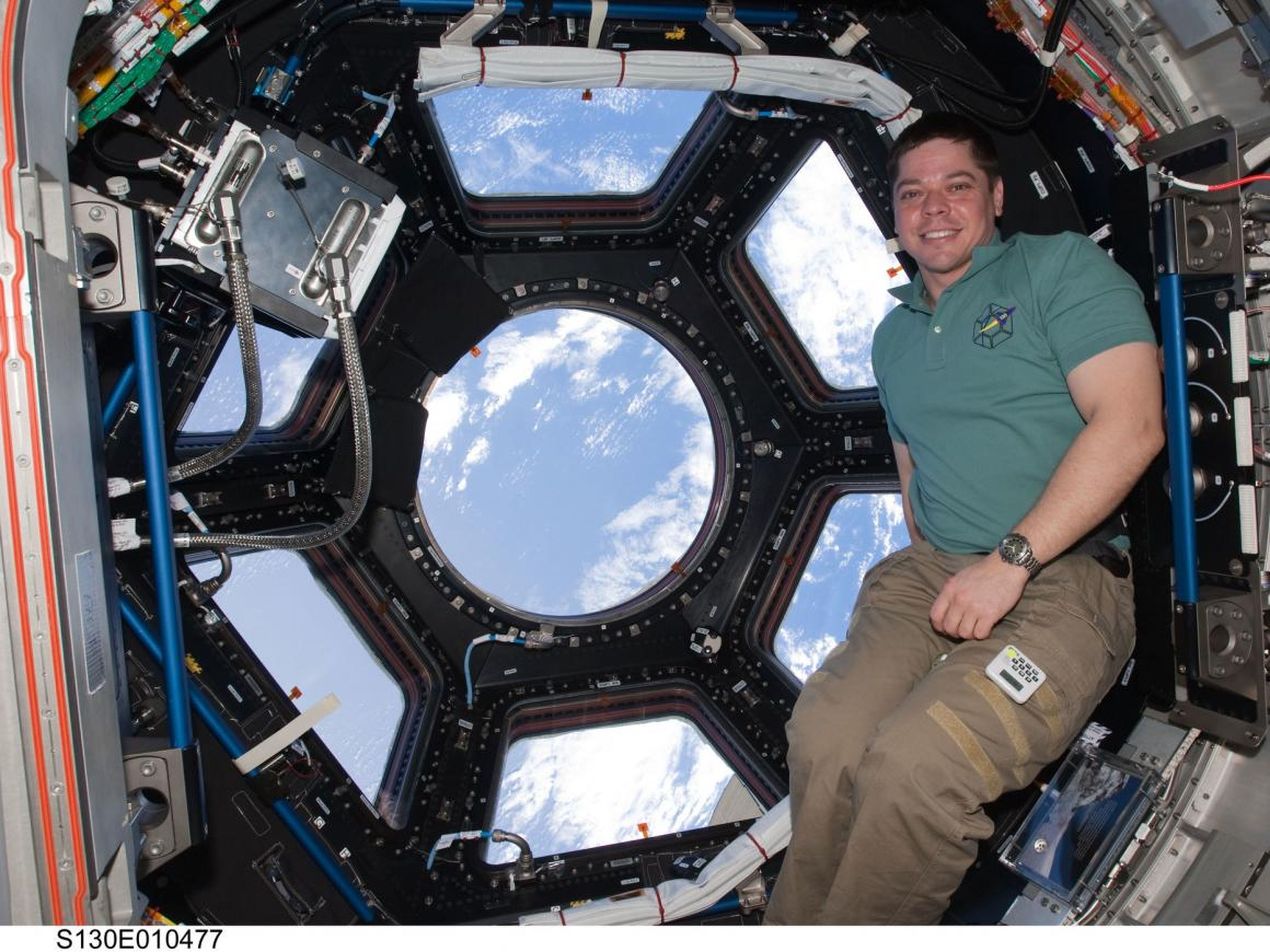 Behnken posando cerca de las ventanas de la Cúpula de la Estación Espacial Internacional.