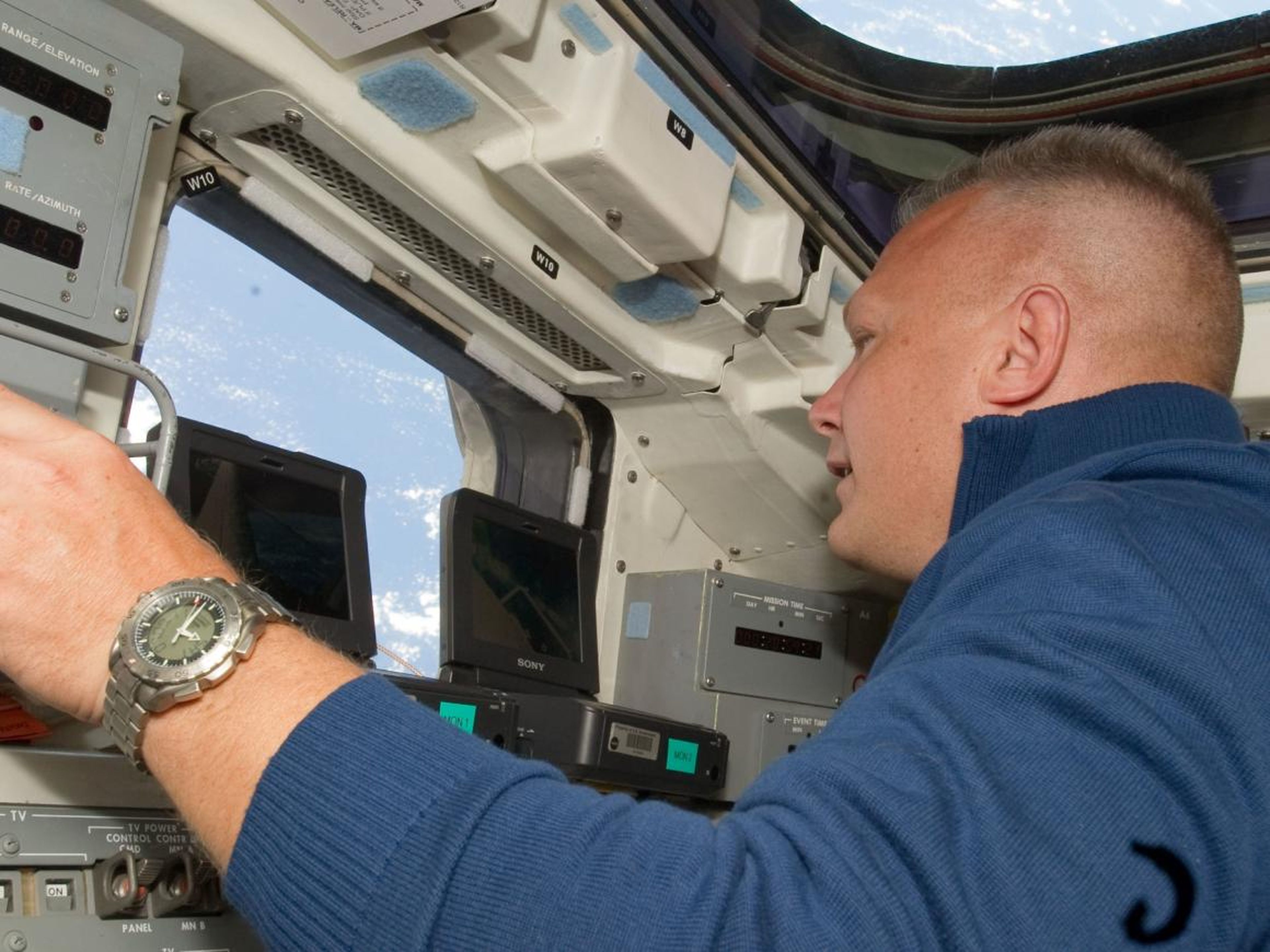 Hurley mirando por la ventana del último transbordador espacial, Atlantis, durante el segundo día de actividades de vuelo en la órbita de la Tierra.