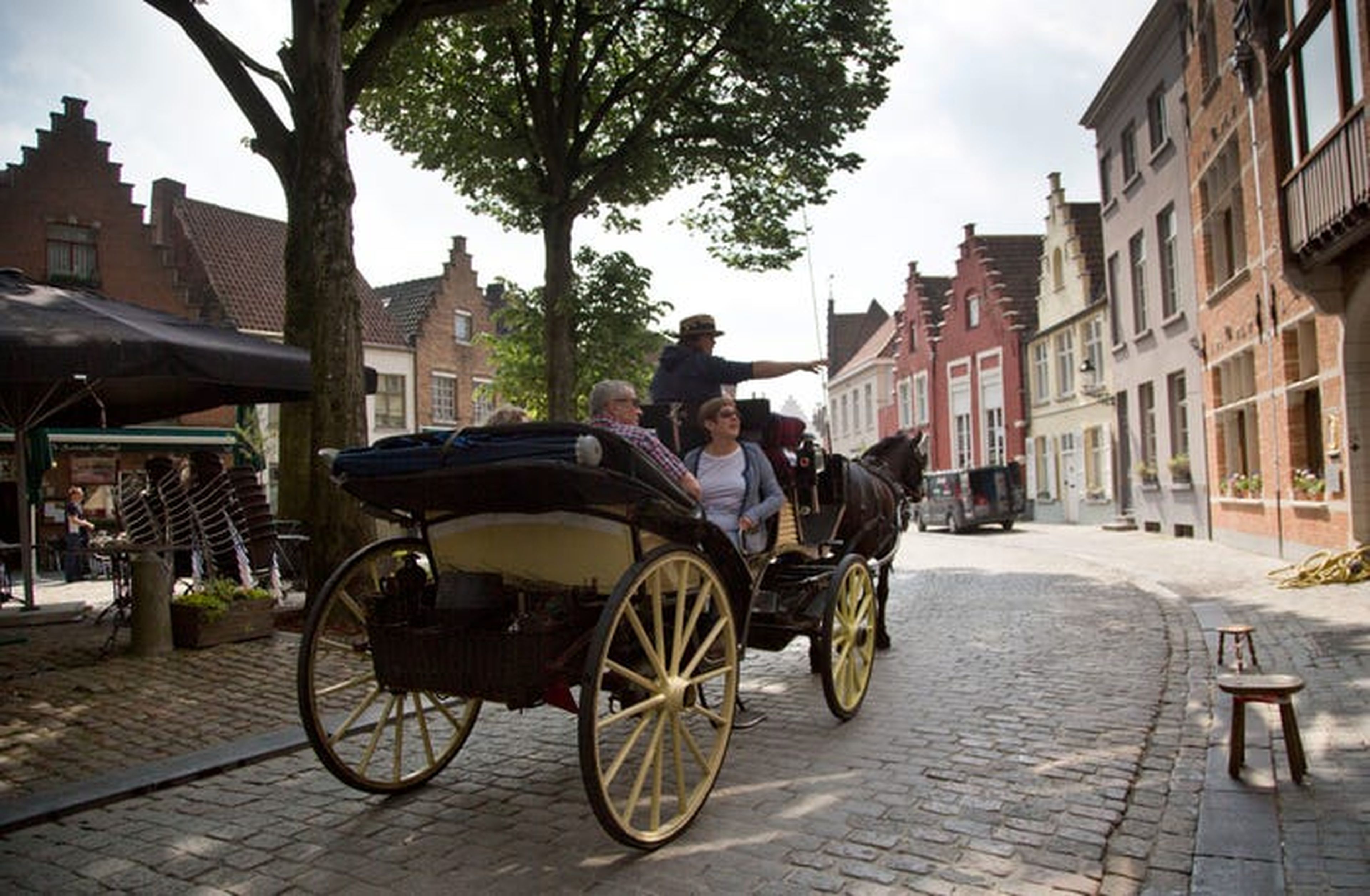 Los turistas viajan en un coche de caballos en Brujas, Bélgica, en 2016.
