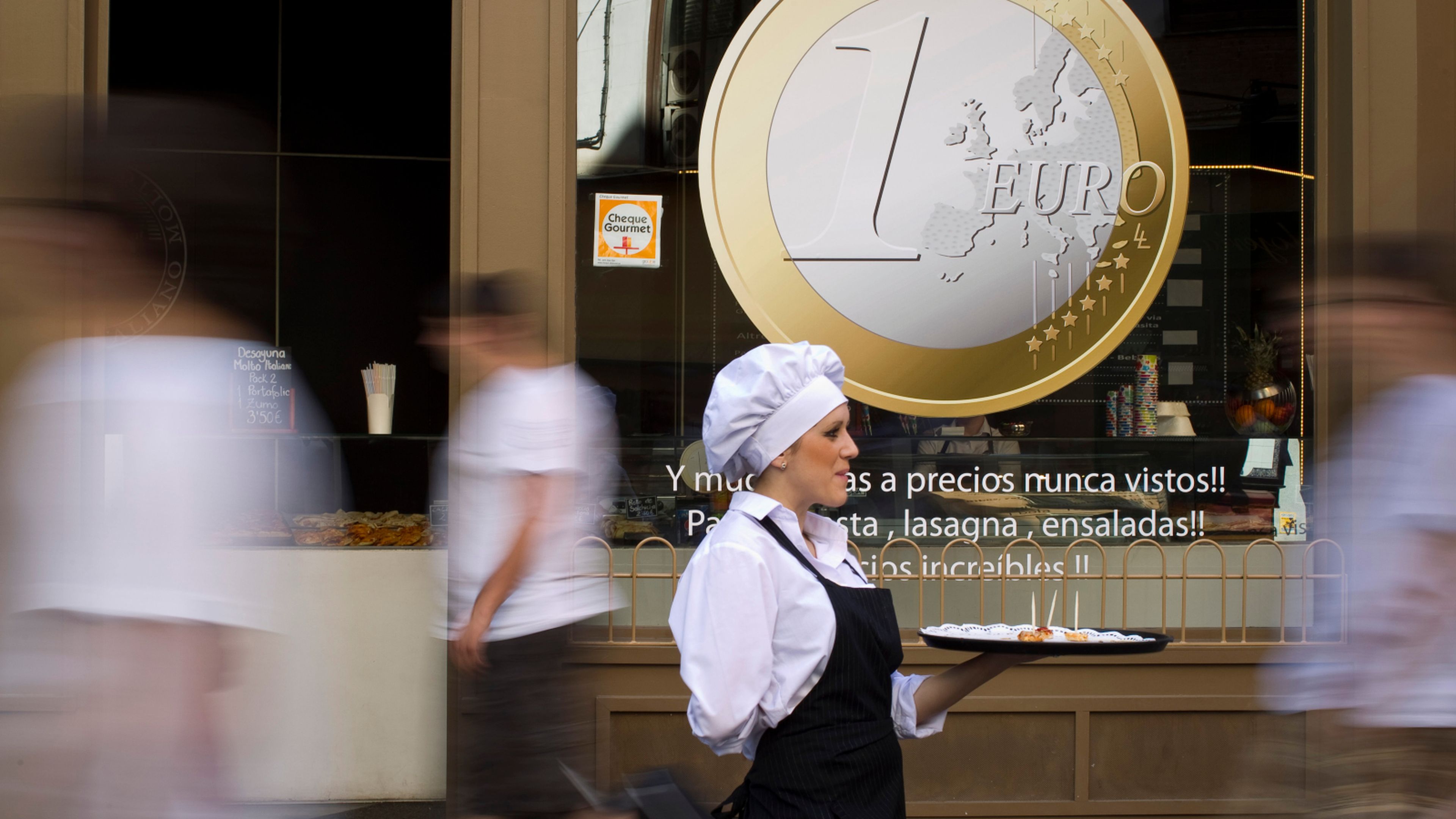 Una camarera ofrece pinchos a los viandantes a la puerta de un restaurante de Madrid