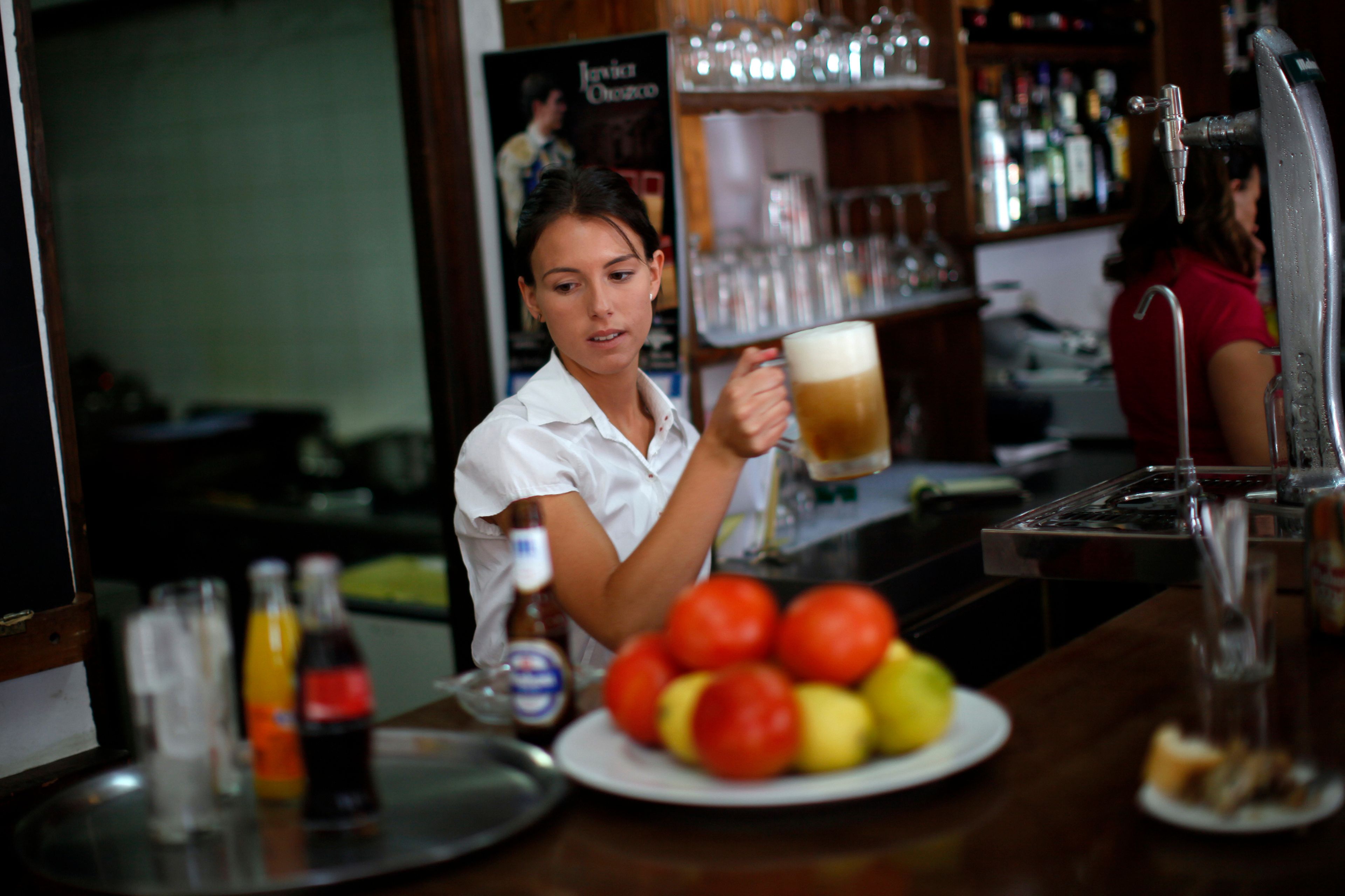 Una camarera sirve una cerveza en un bar de Ronda (Málaga)