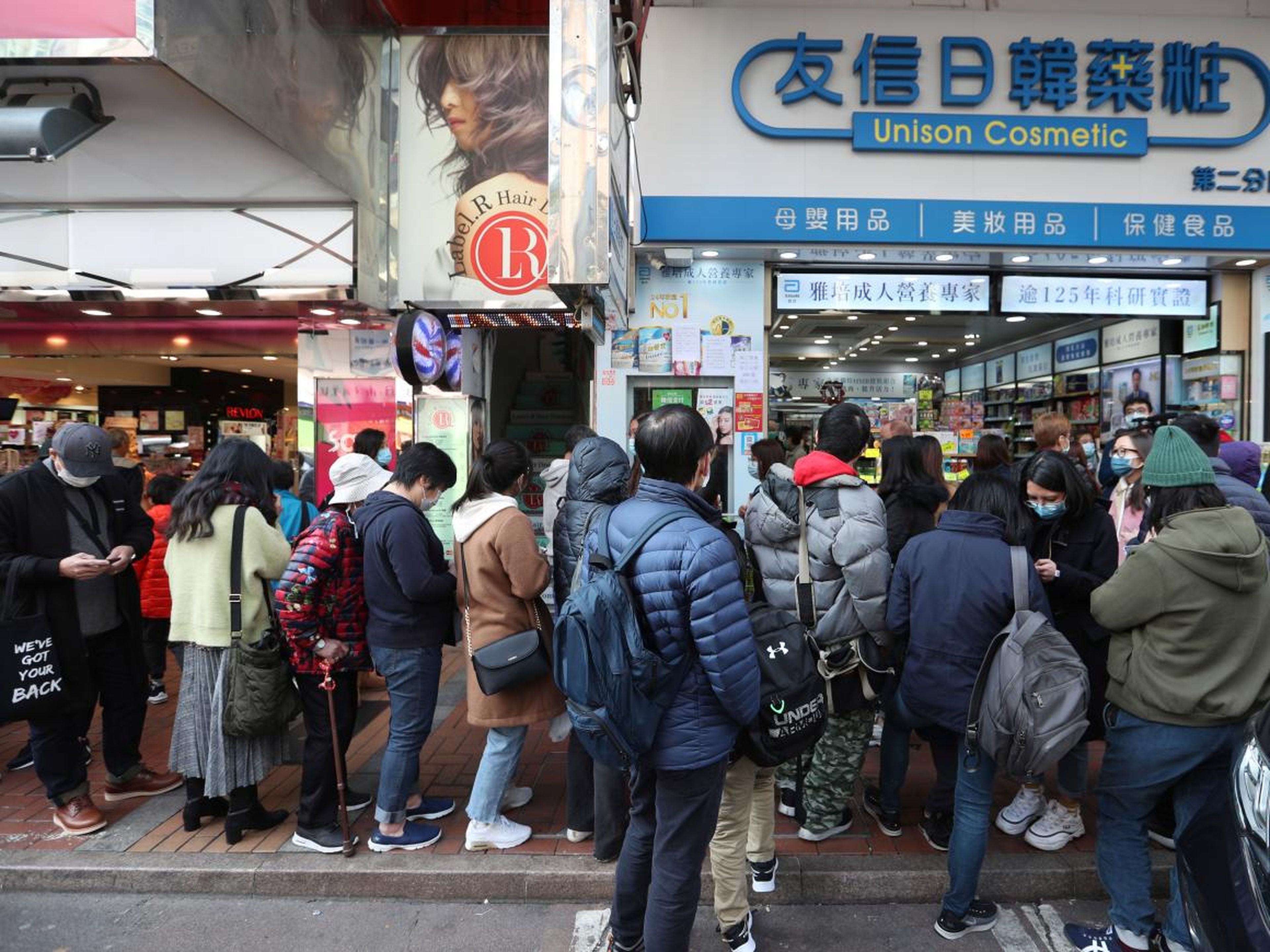 La gente hace cola para recibir mascarillas gratuitas en el exterior de una tienda de cosméticos en Tsuen Wan, Hong Kong, el 28 de enero.