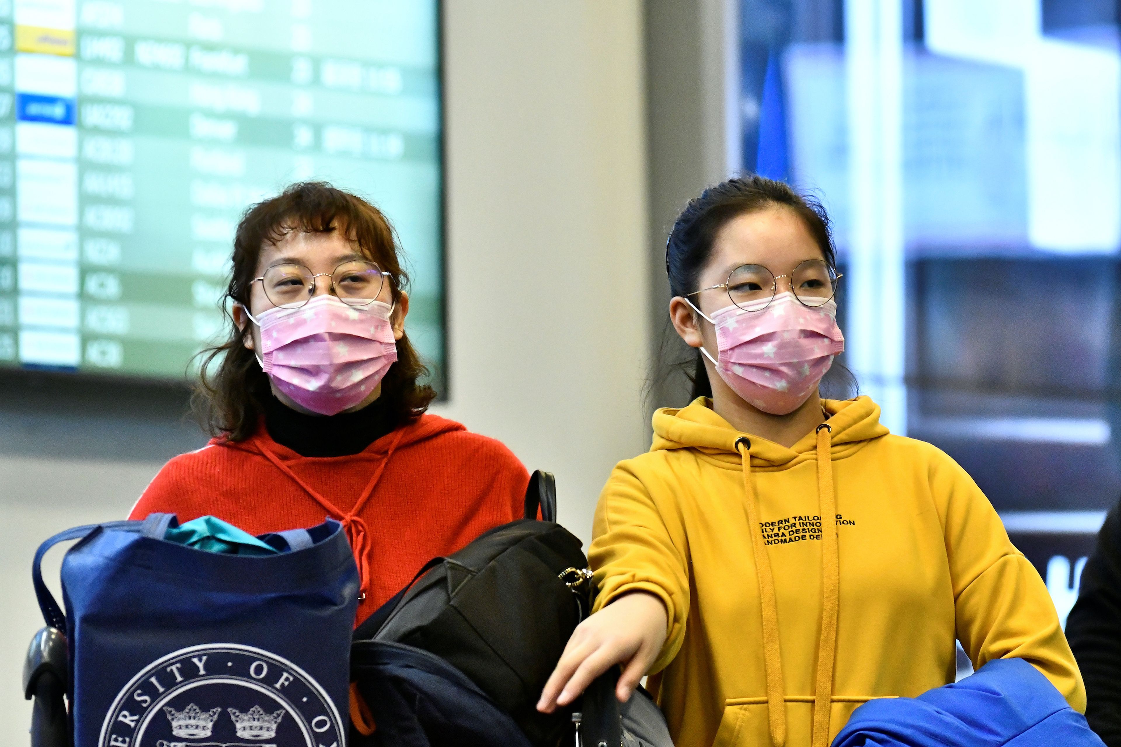 Los viajeras llevando máscaras llegan al aeropuerto de Vancouver, Canadá, desde China.