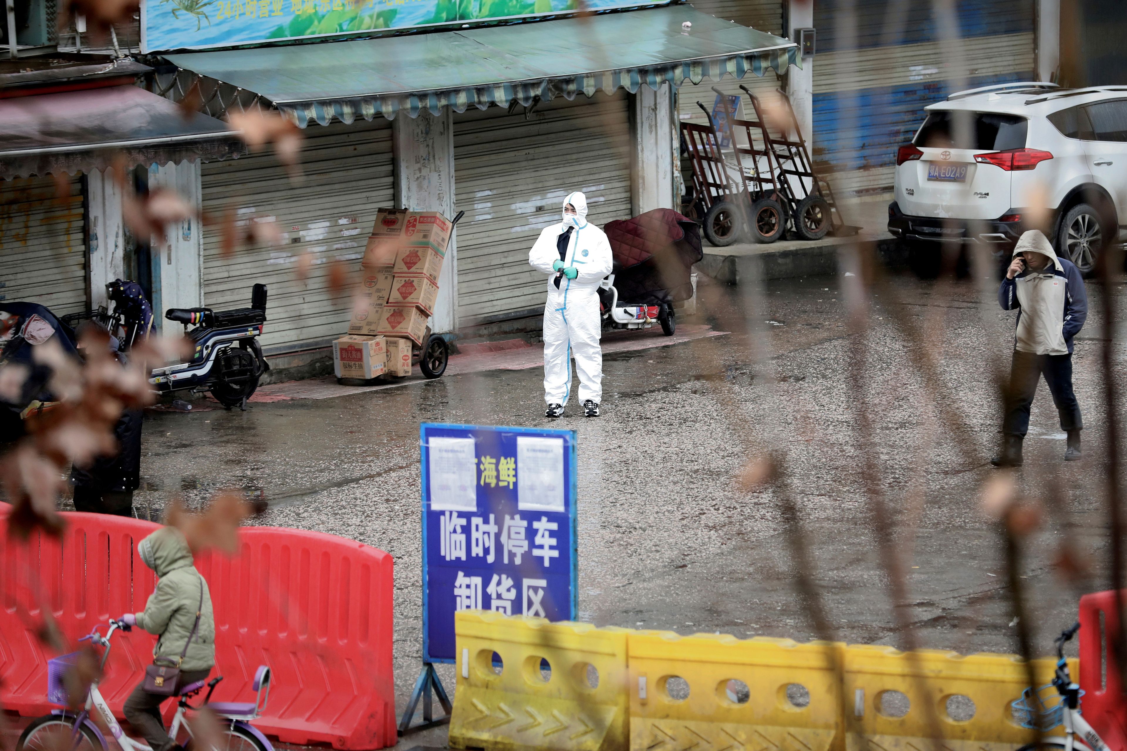 Un trabajador con un traje protector inspecciona las inmediaciones del mercado de marisco de Wuhan, epicentro del coronavirus.