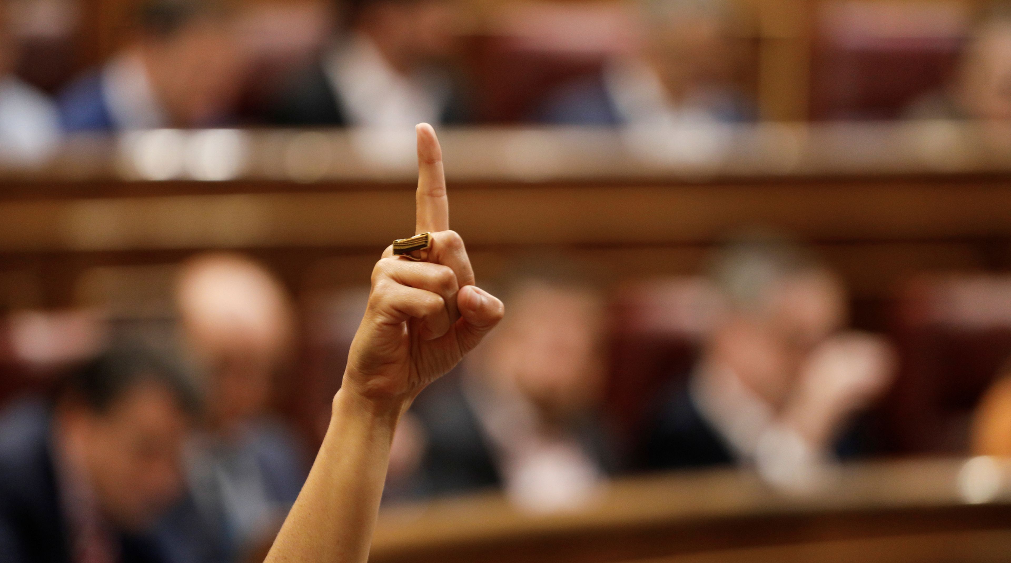 Una diputada levanta la mano en el Congreso de los Diputados para marcar el sentido de voto a sus compañeros de partido