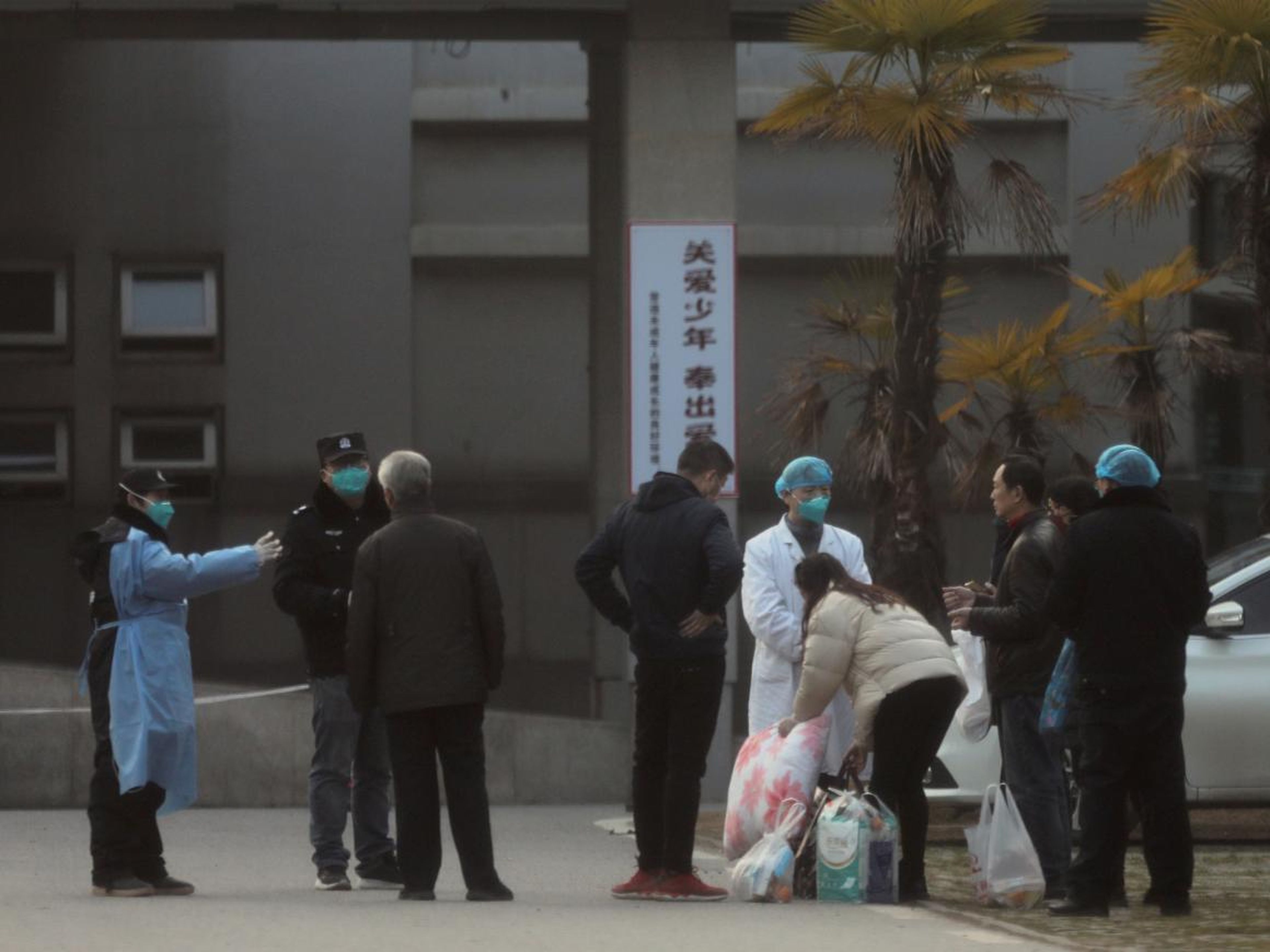 Trabajadores médicos y personal de seguridad evitando que los familiares de los pacientes se acerquen demasiado al Hospital de Jinyintan, donde se está tratando a pacientes enfermos de neumonía causada por el coronavirus en Wuhan.