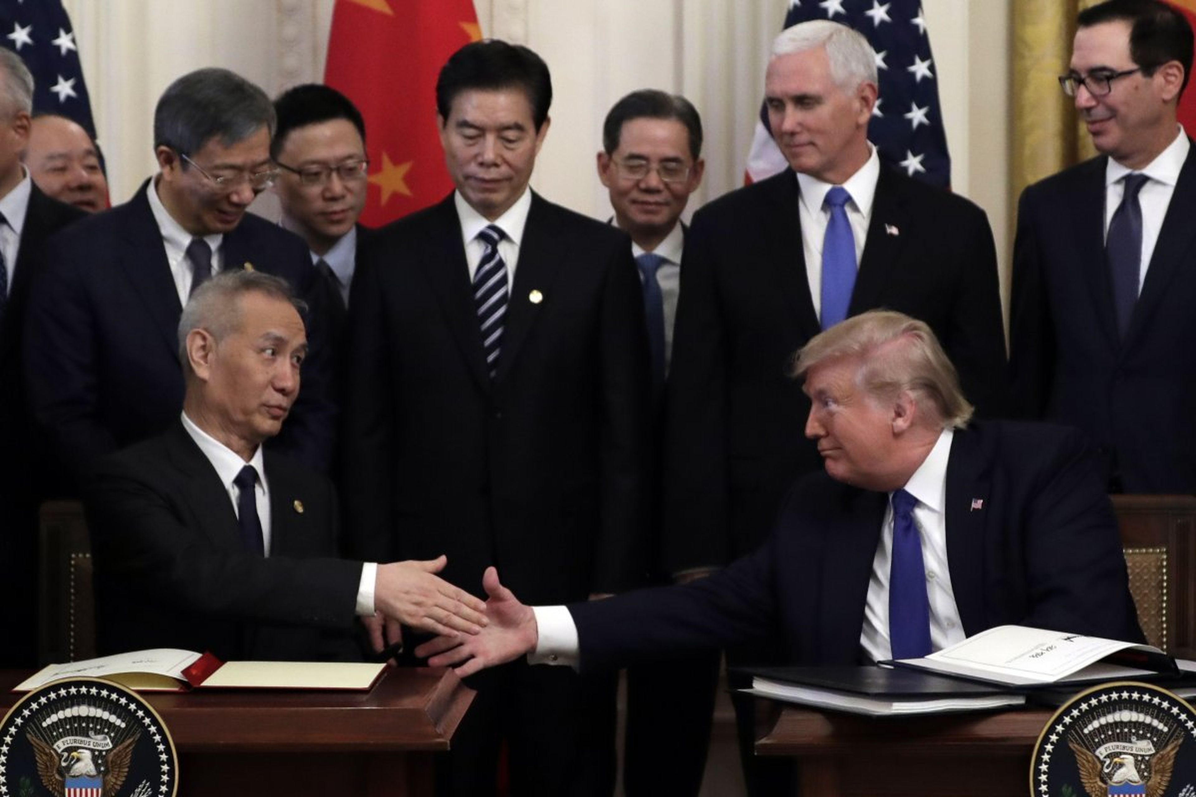 Donald Trump, presidente de Estados Unidos, le da la mano al viceprimer ministro chino Liu He, después de firmar el acuerdo comercial.