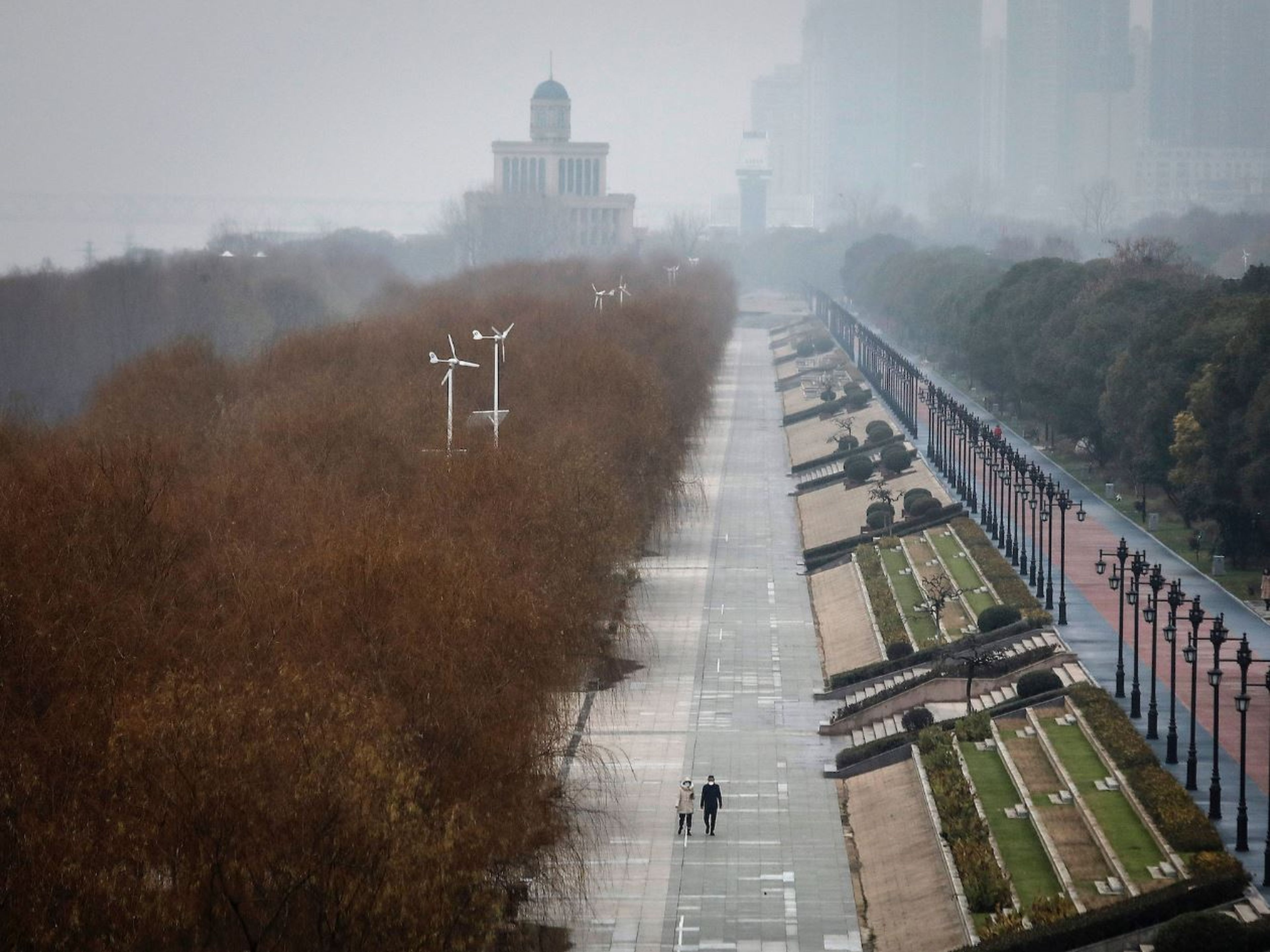 Dos residentes caminan en un parque vacío de Jiangtan el 27 de enero de 2020 en Wuhan, China.