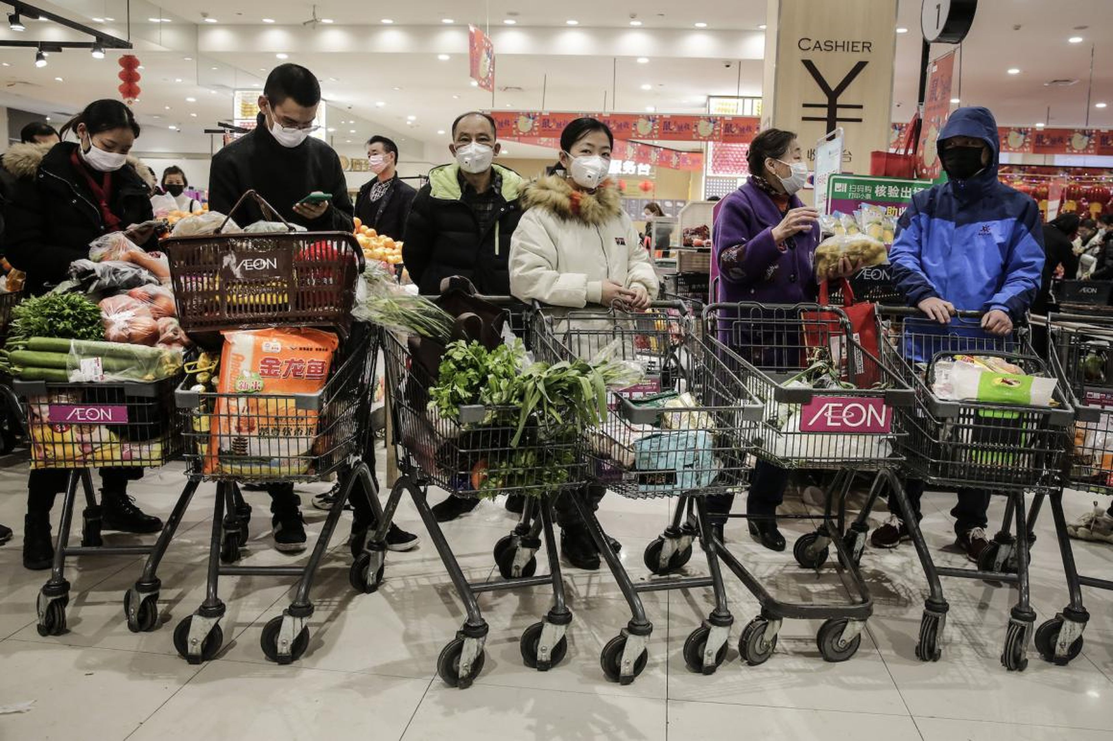 Los residentes de Wuhan usan máscaras cuando compran alimentos el 23 de enero de 2020.