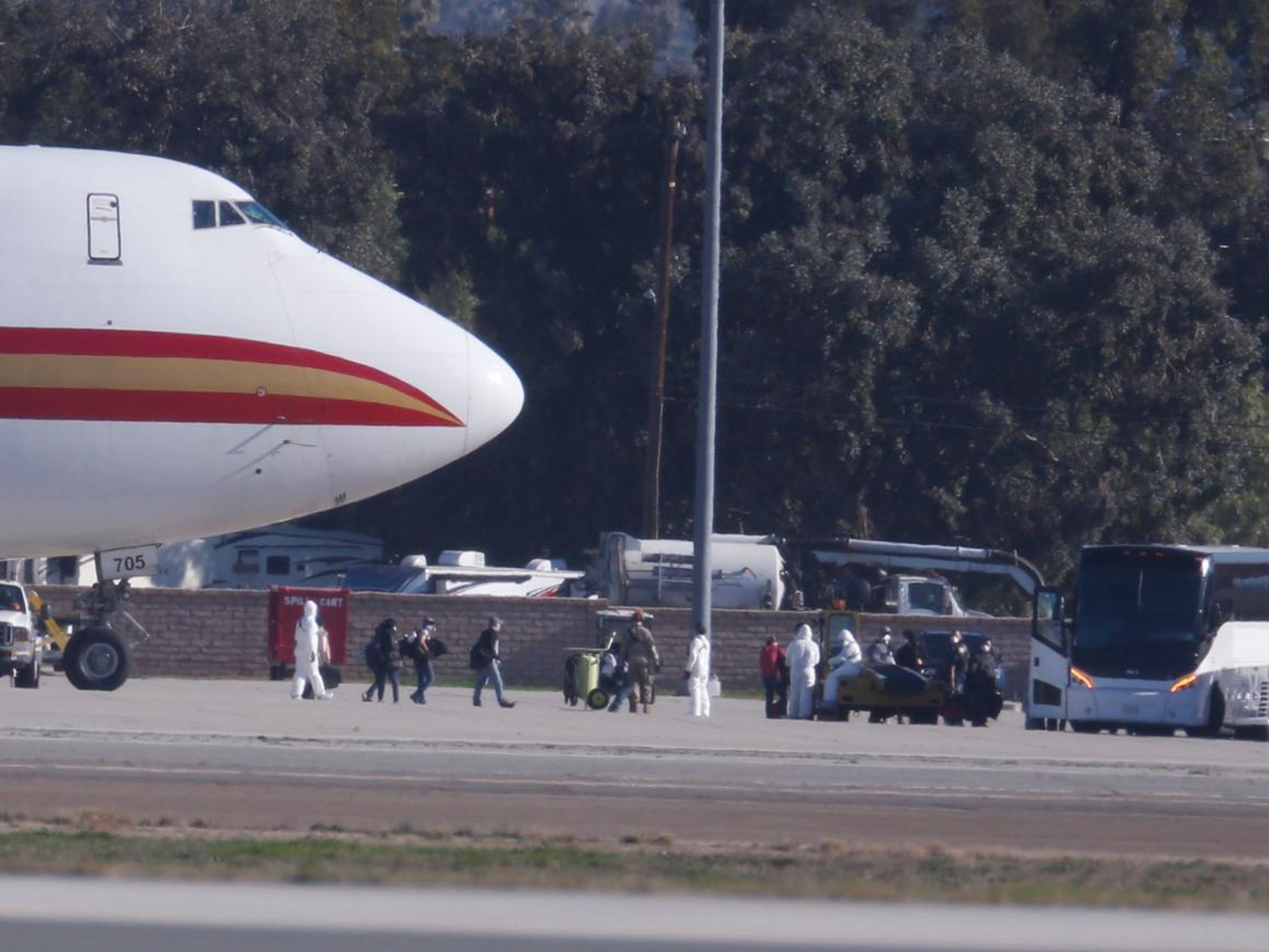 Pasajeros subiendo a autobuses en la Base de la Reserva Aérea de March en Riverside, California, el 29 de enero después de ser evacuados de Wuhan.