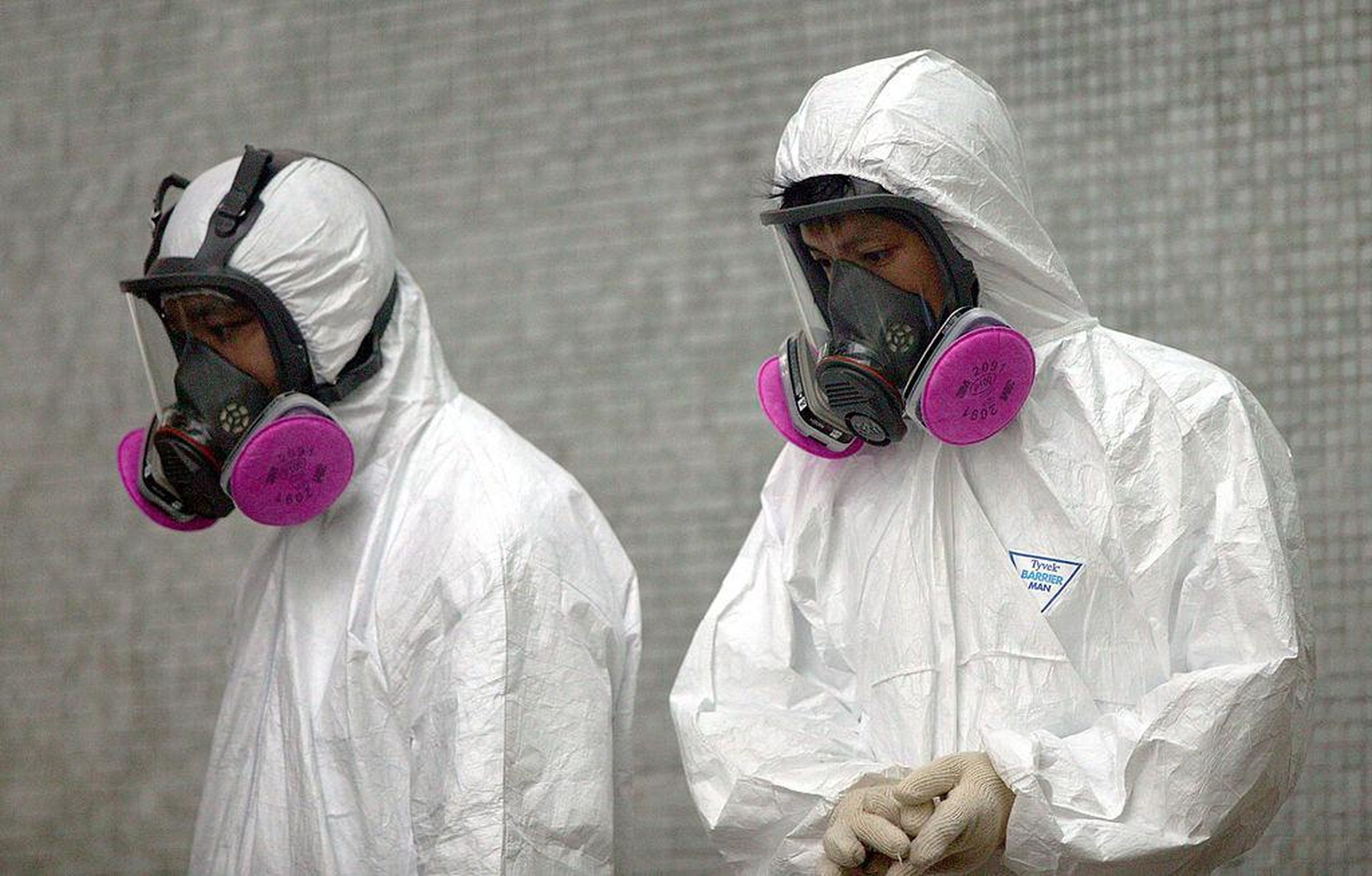 Health workers wear full protective clothing during cleanup operations at Amoy Gardens, where over 200 residents were infected with the SARS (Severe Acute Respiratory Syndrome) virus, April 4, 2003 in Hong Kong.