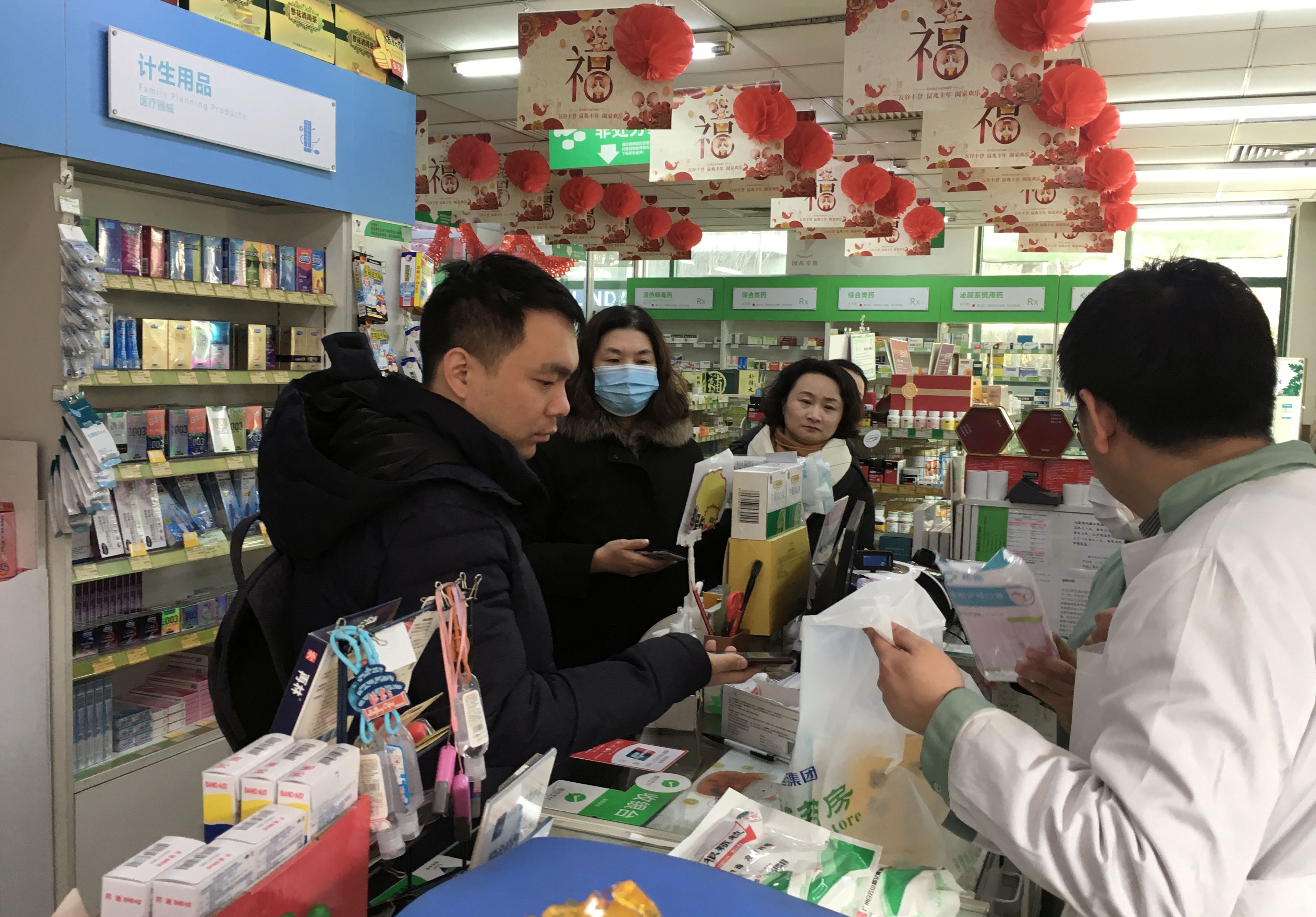 Un hombre compra mascarillas en una farmacia en Pekín.