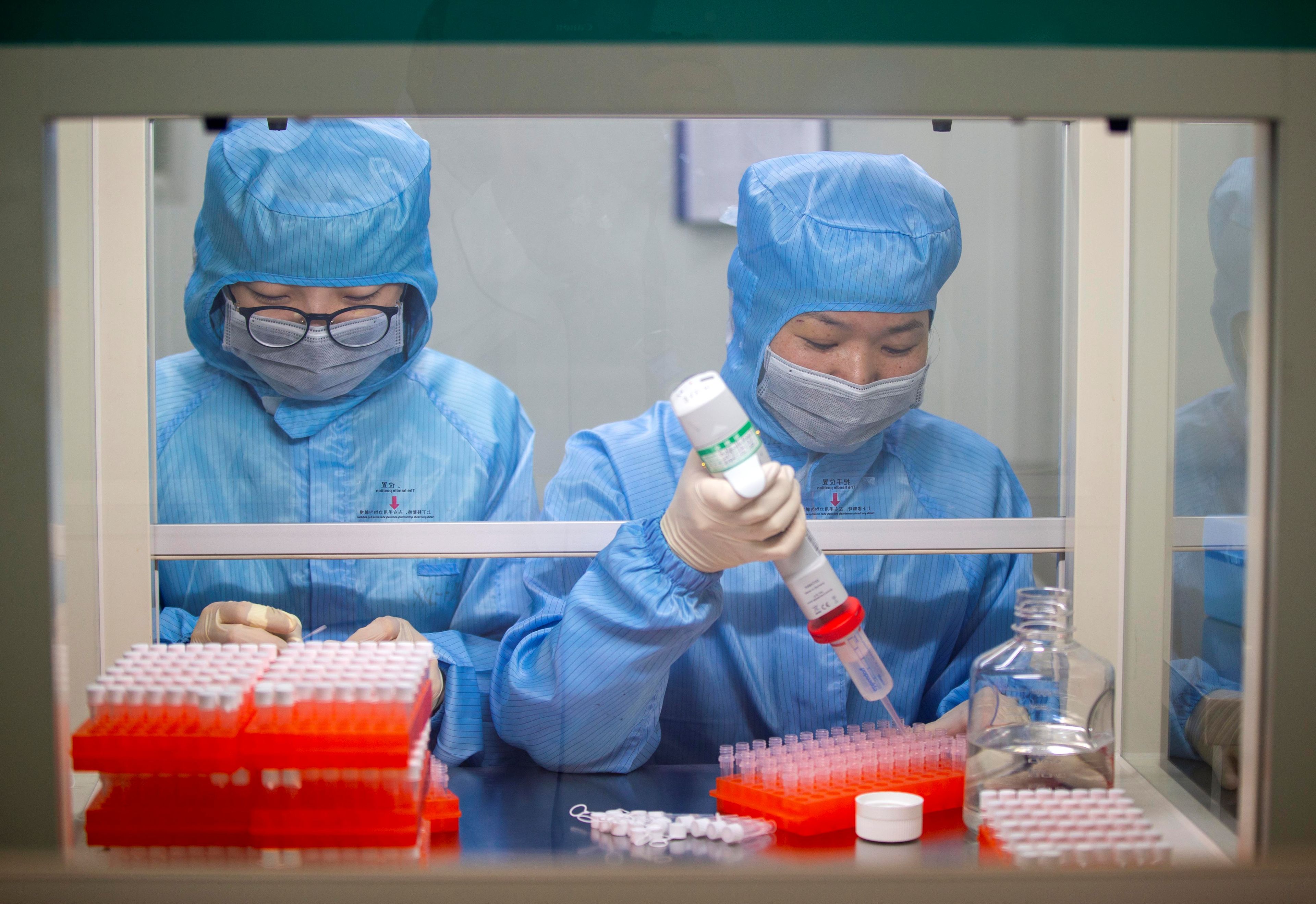 Médicos vestidos con trajes protectores en China analizan muestras del coronavirus de Wuhan