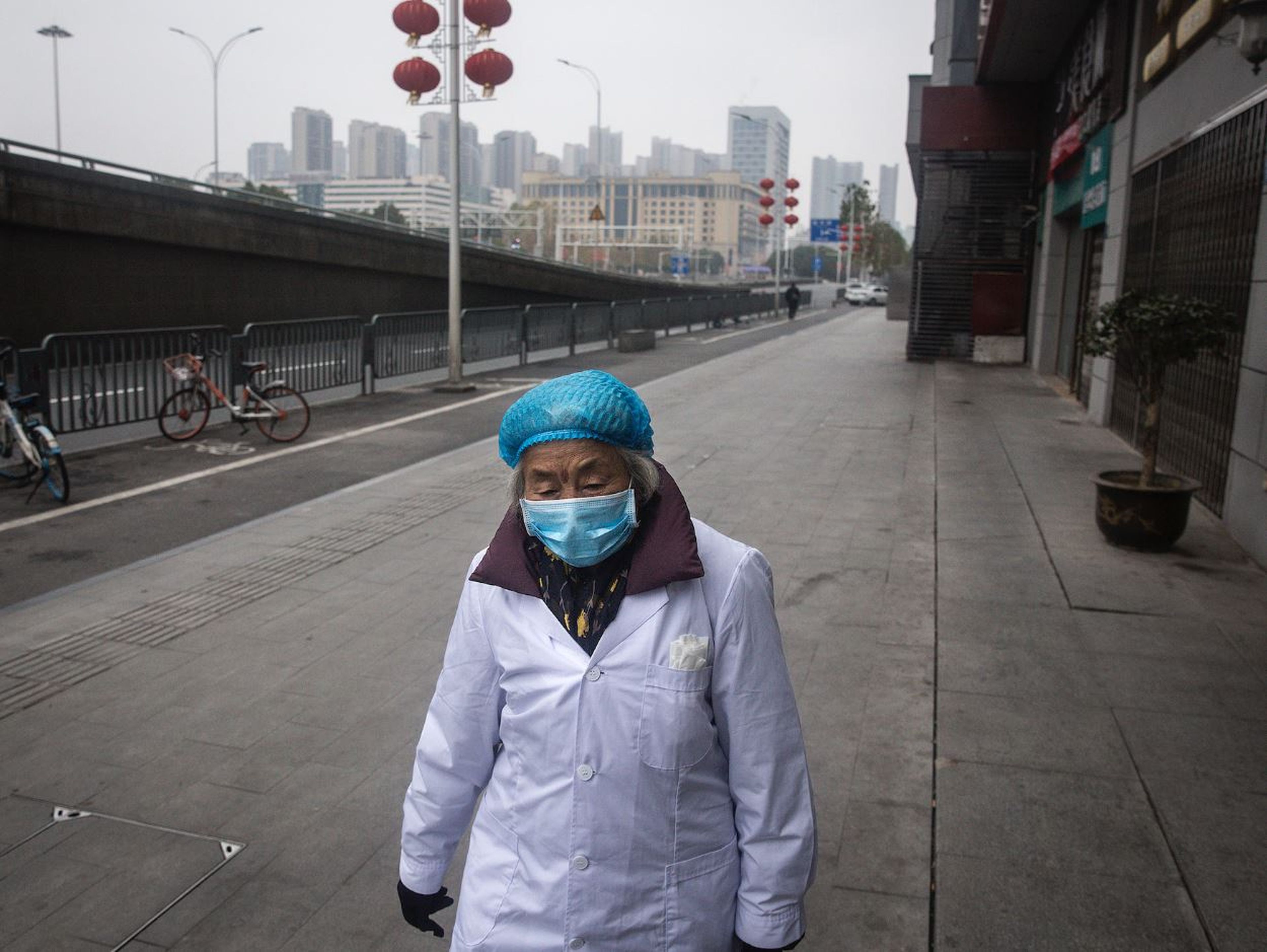 Una mujer camina con una máscara protectora en Wuhan.