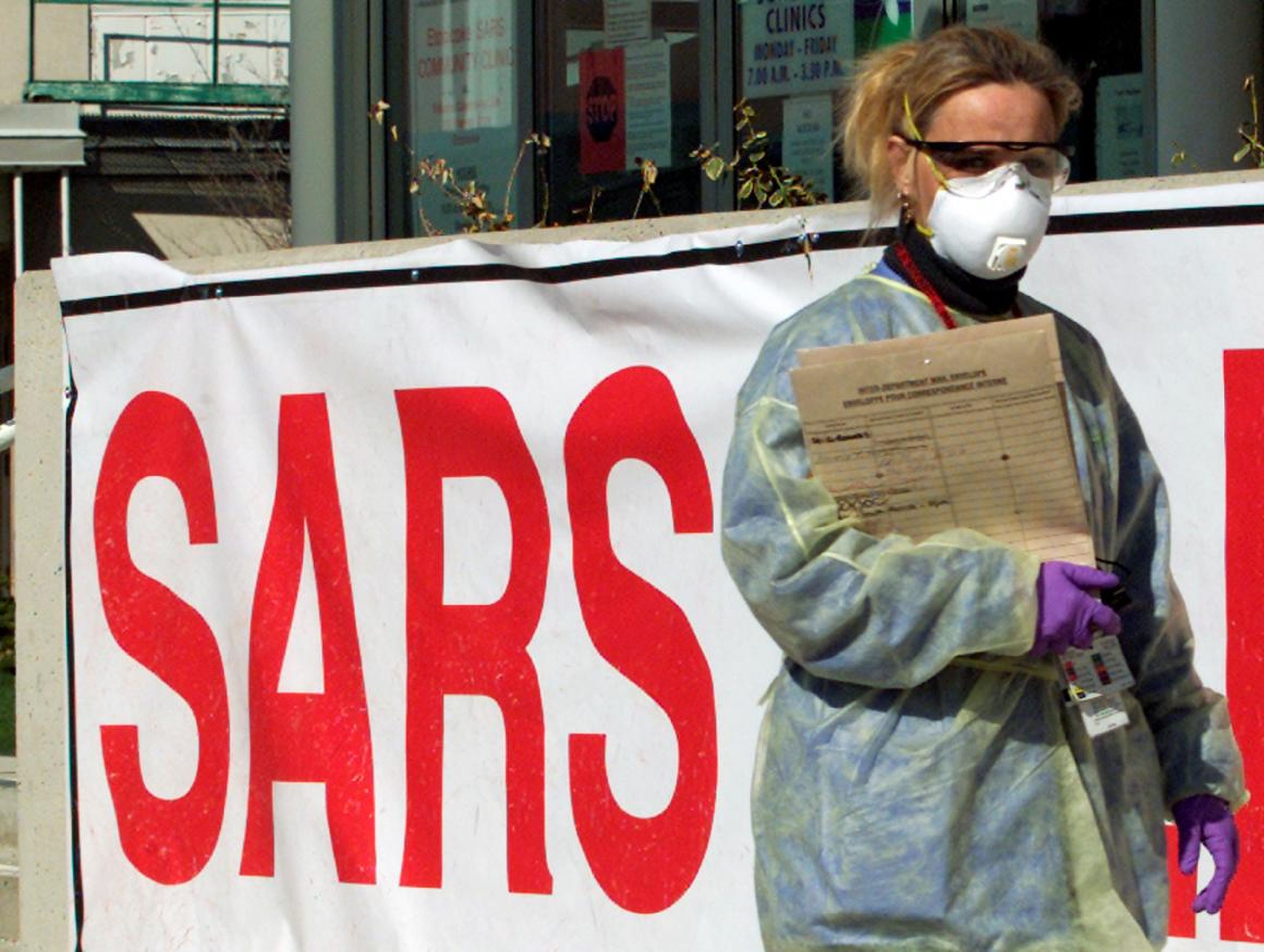 A nurse wearing protective gear walks outside a Severe Acute Respiratory Syndrome (SARS) clinic in suburban Toronto, 2003.