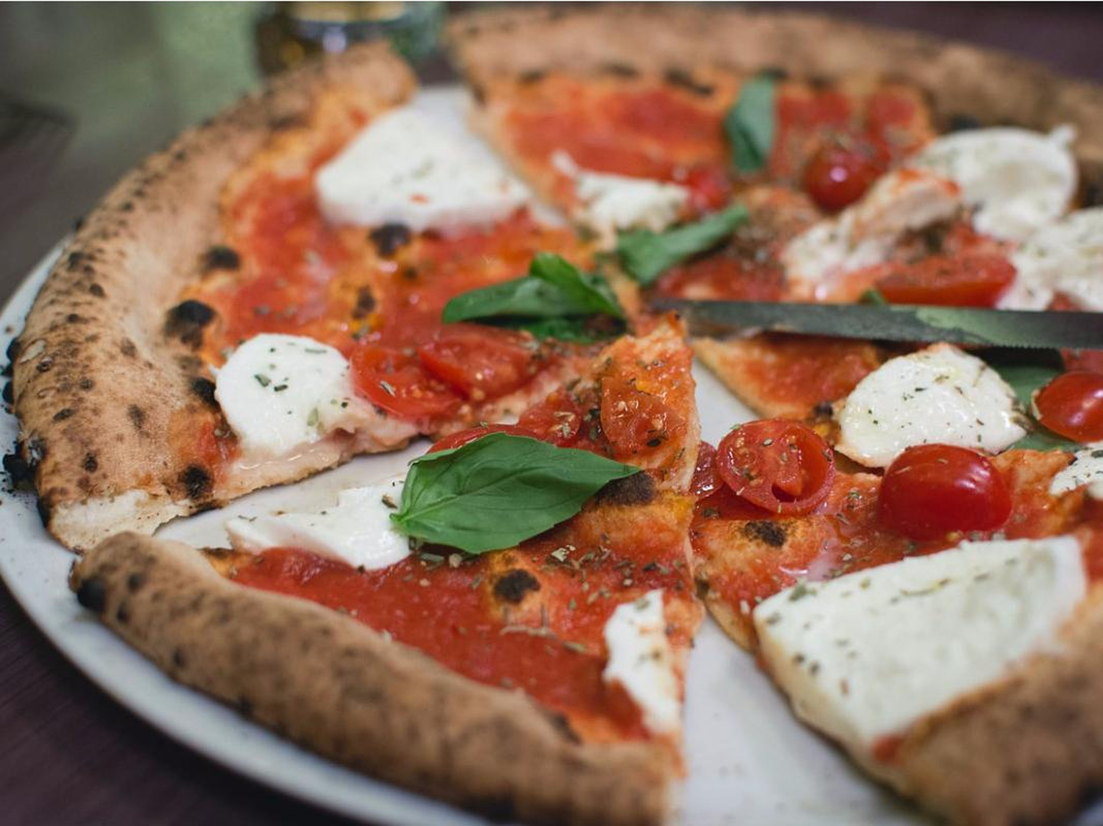 La pizza margarita está hecha con mozzarella fresca, tomate y albahaca.