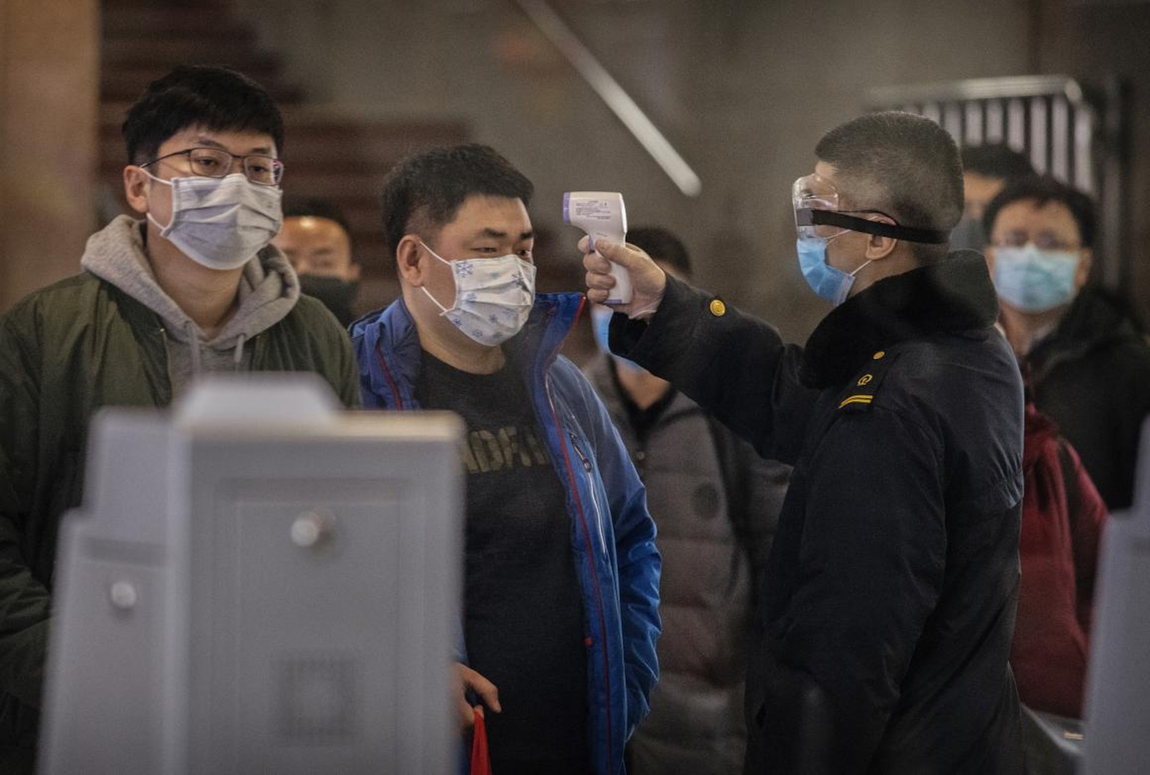 Pasajeros recién llegados en tren desde Wuhan son examinados en Pekín para detectar la presencia del coronavirus.