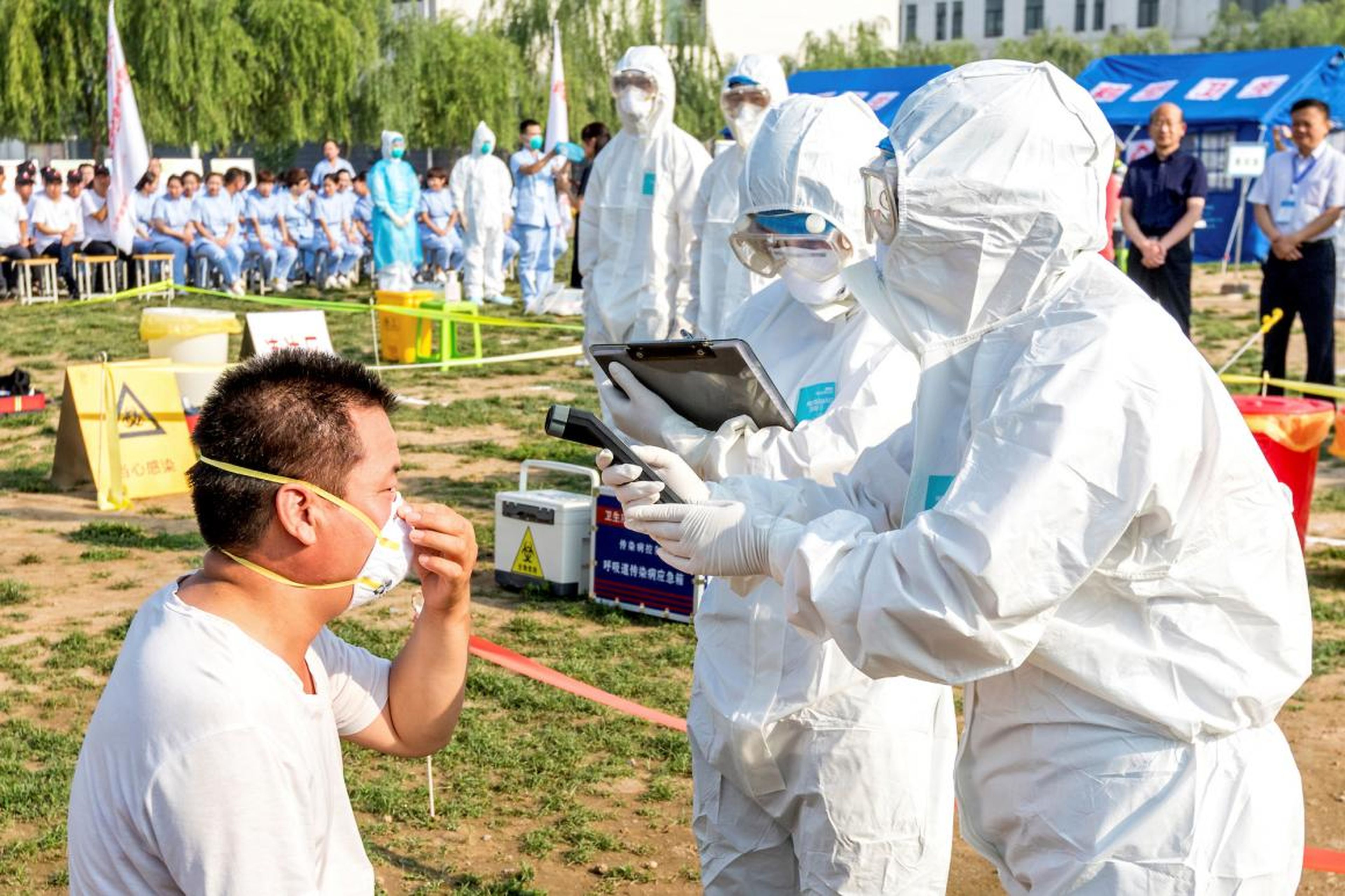 People participate in an emergency exercise on prevention and control of H7N9 bird flu virus organized by the local government in Hebi, Henan province, China, June 17, 2017.