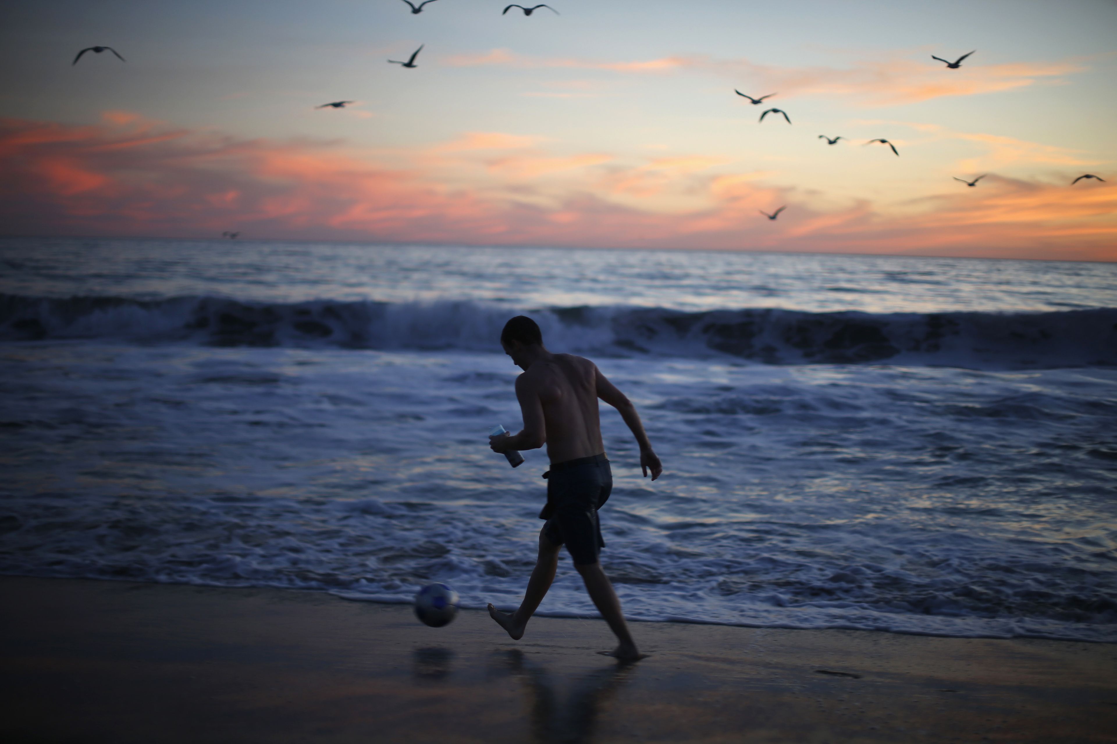 Un joven juega en la orilla de la playa de Santa Mónica, en California.