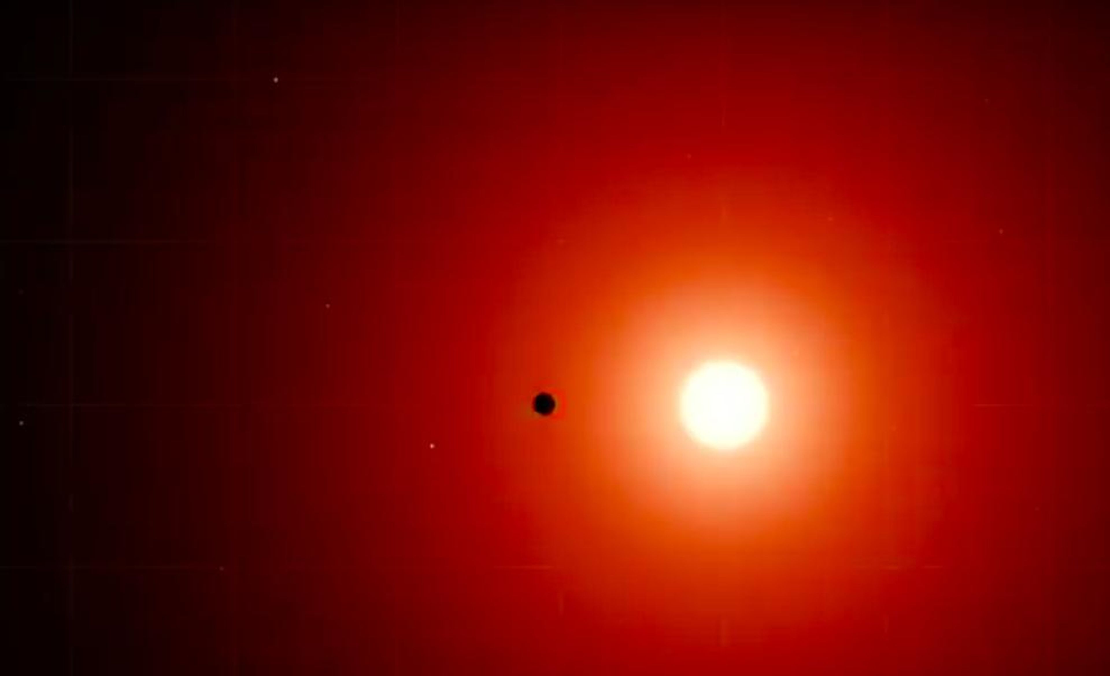 Fotografía de la estrella enana roja TOI 700 con uno de sus planetas pasado por delante.