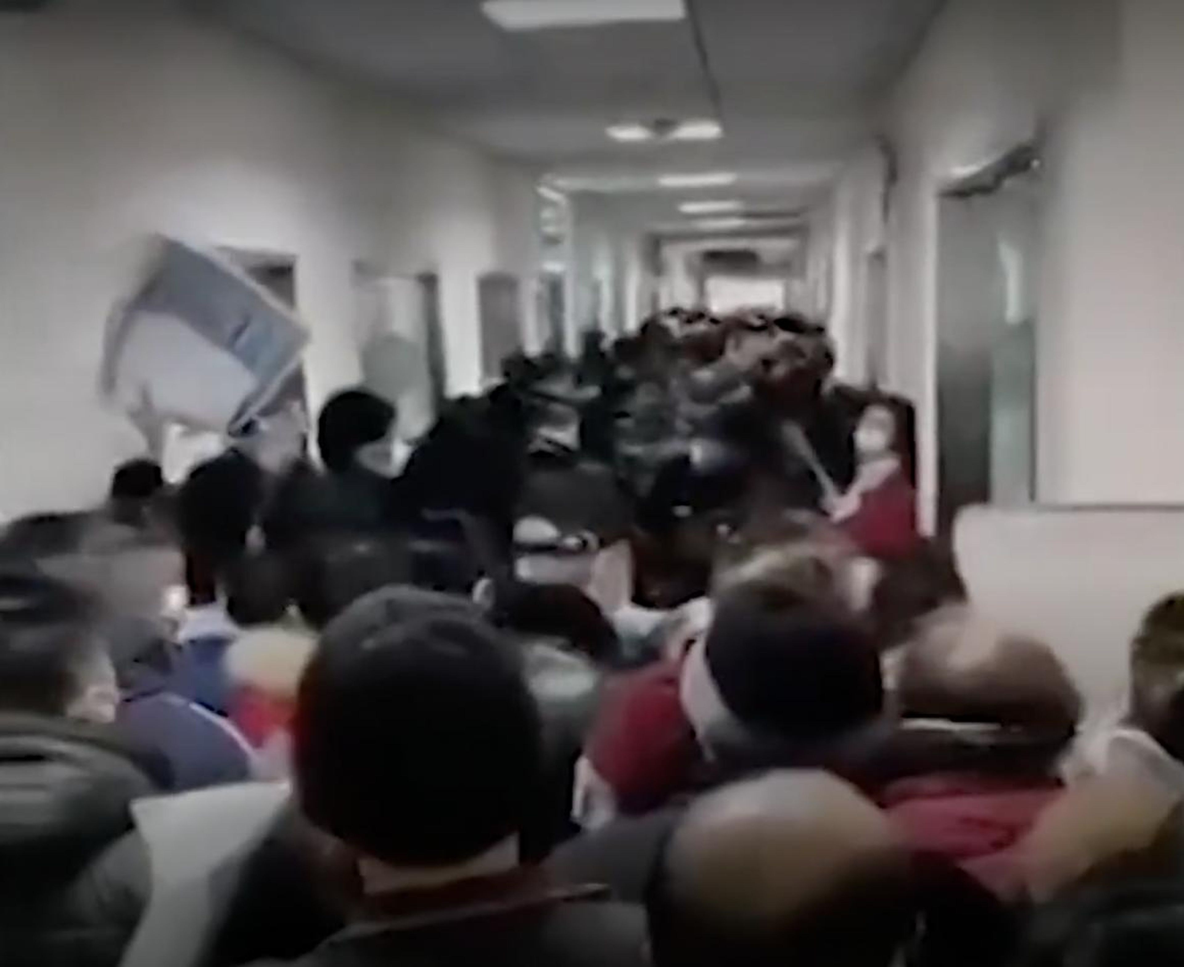 Una foto de un video del New York Times muestra a gente amontonándose en un pasillo de un hospital en Wuhan, China, en medio del brote de coronavirus.