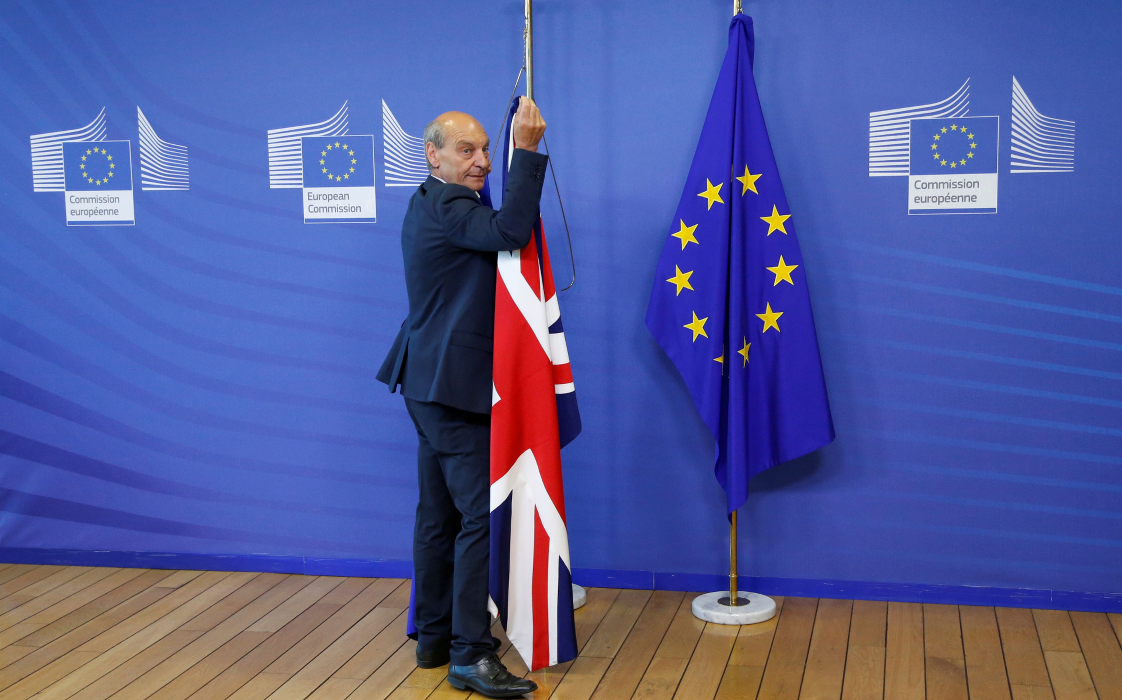 Un trabajador de la Comisión Europea retira la bandera británica