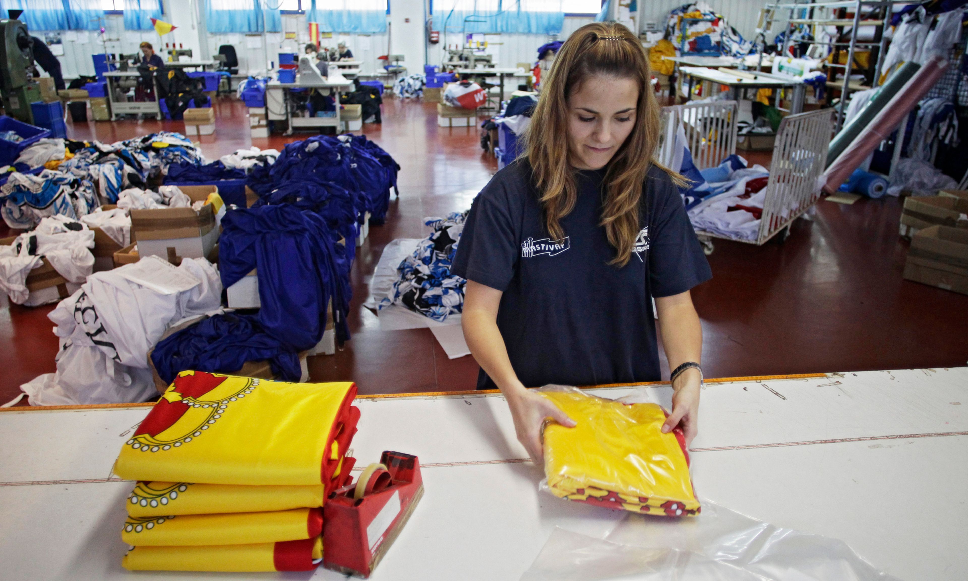 Una trabajadora empaqueta banderas en una fábrica