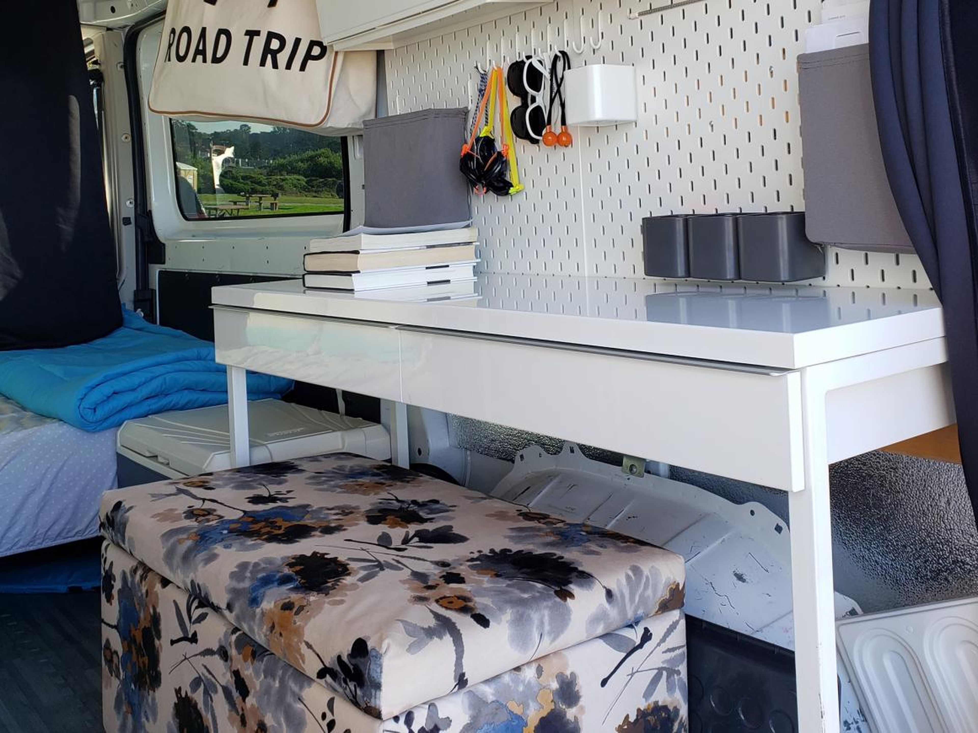 The van has a rear kitchen, bed, desk, and storage units such as overhead cabinets and drawers. Aquino claims a desk is considered a luxury for those living the #VanLife.