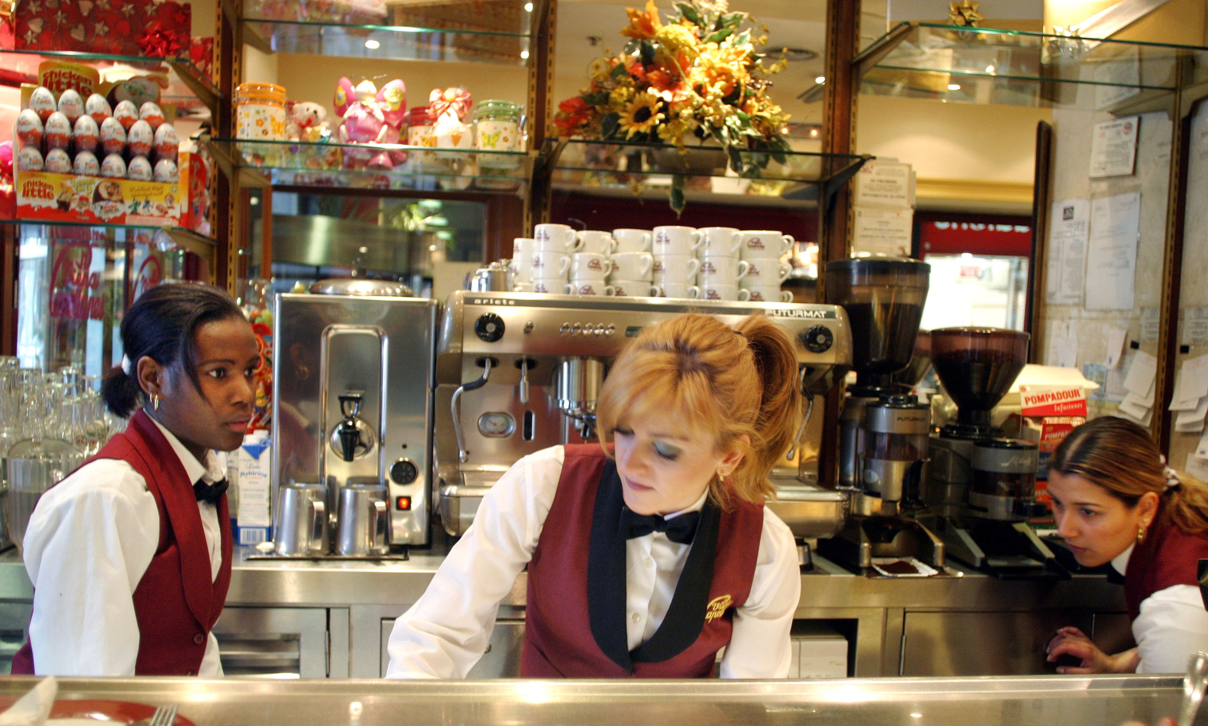 3 camareras trabajan tras la barra de una cafetería en Madrid
