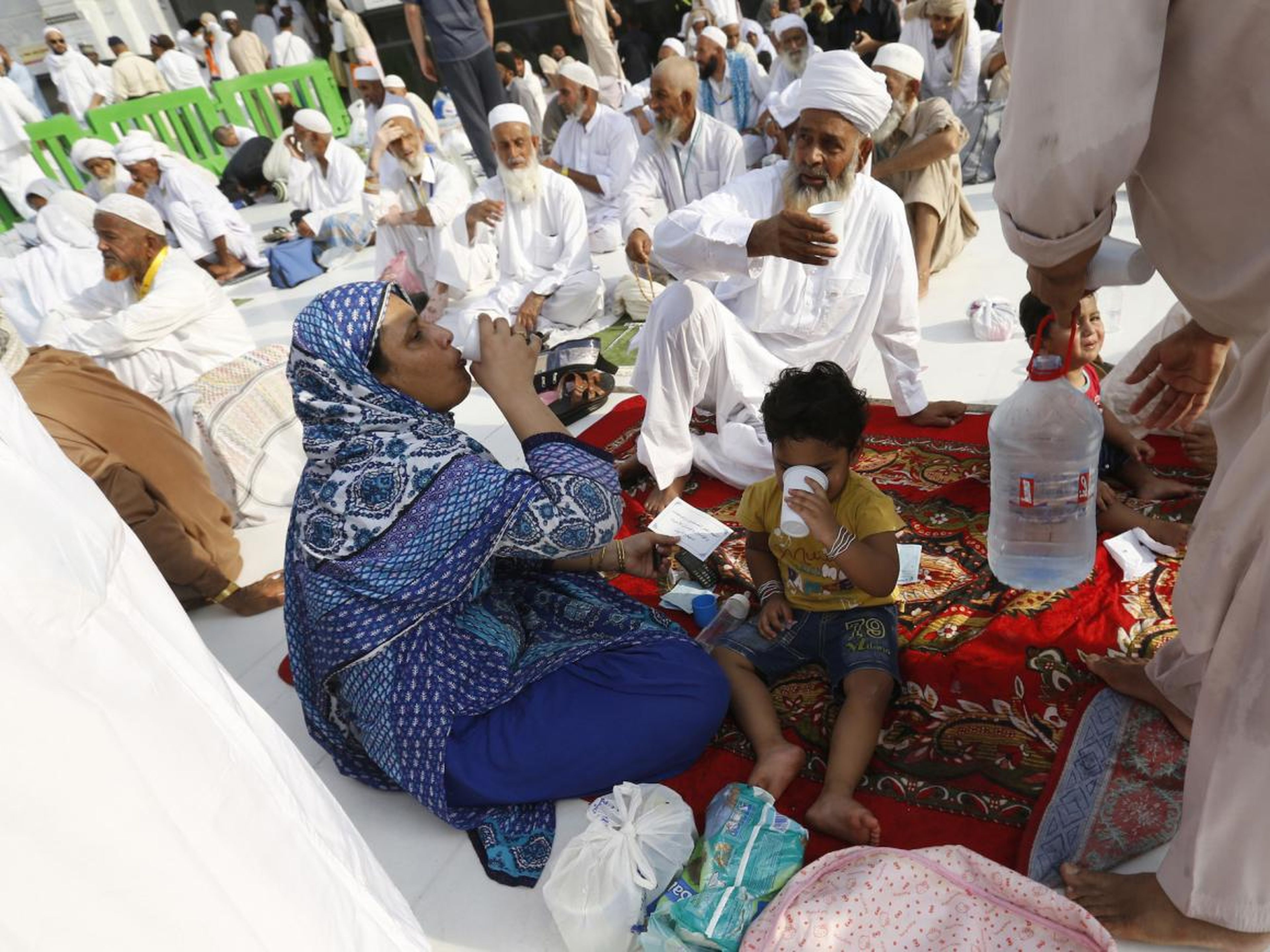 Gente sentada en la acera alrededor de la Gran Mezquita.