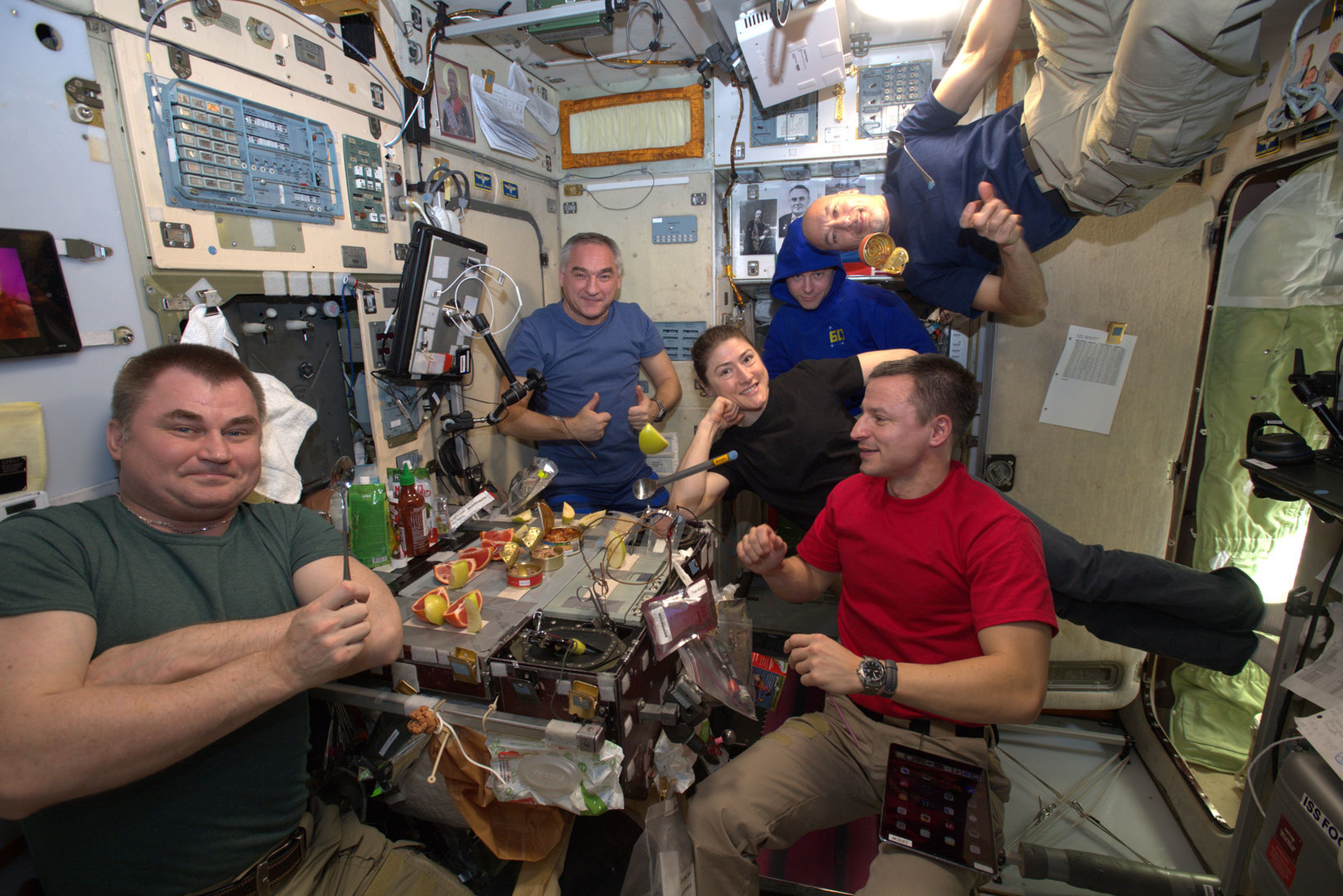 Astronautas de la Estación Espacial Internacional comiendo.