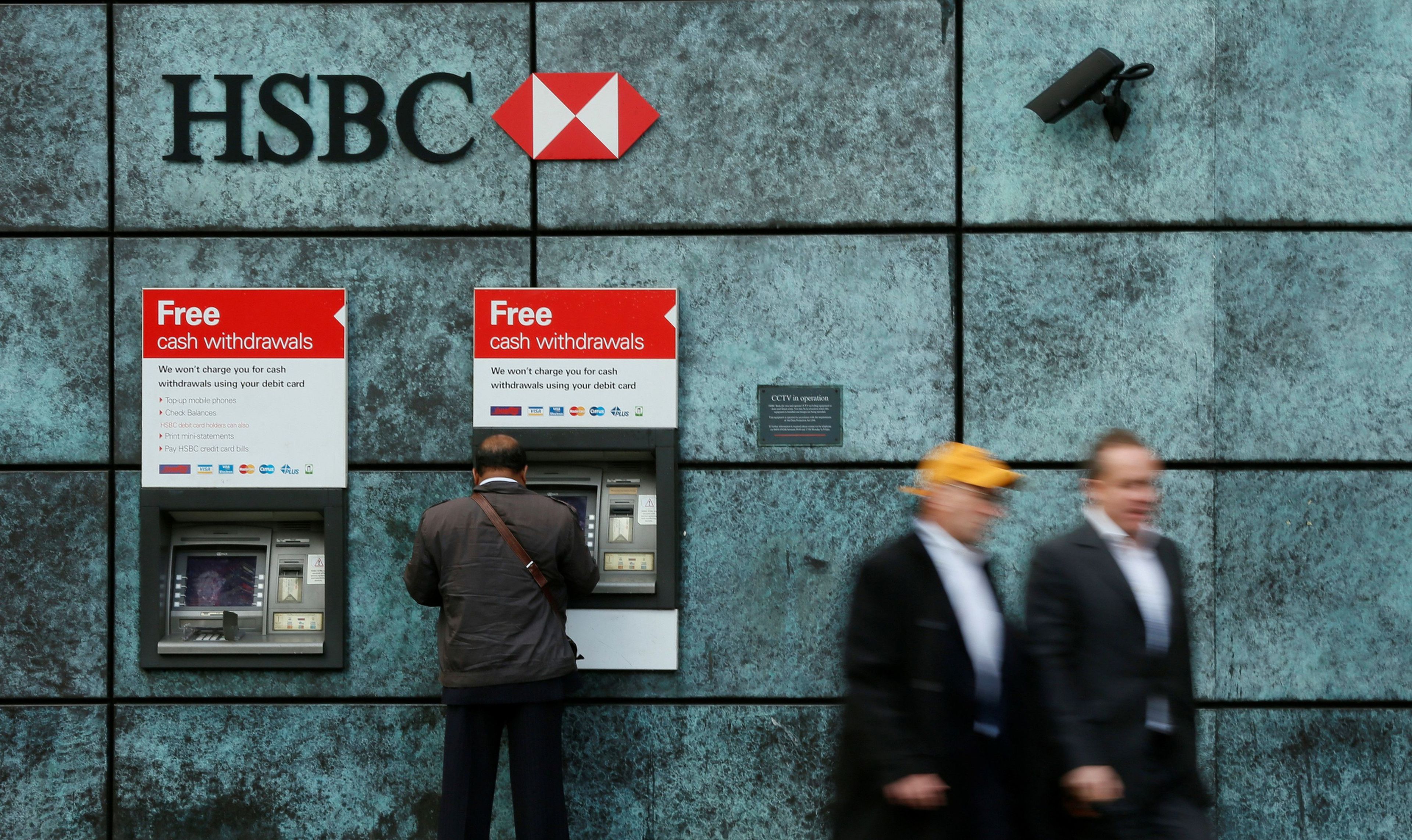 Un cliente retira efectivo en un cajero automático de HSBC en Londres