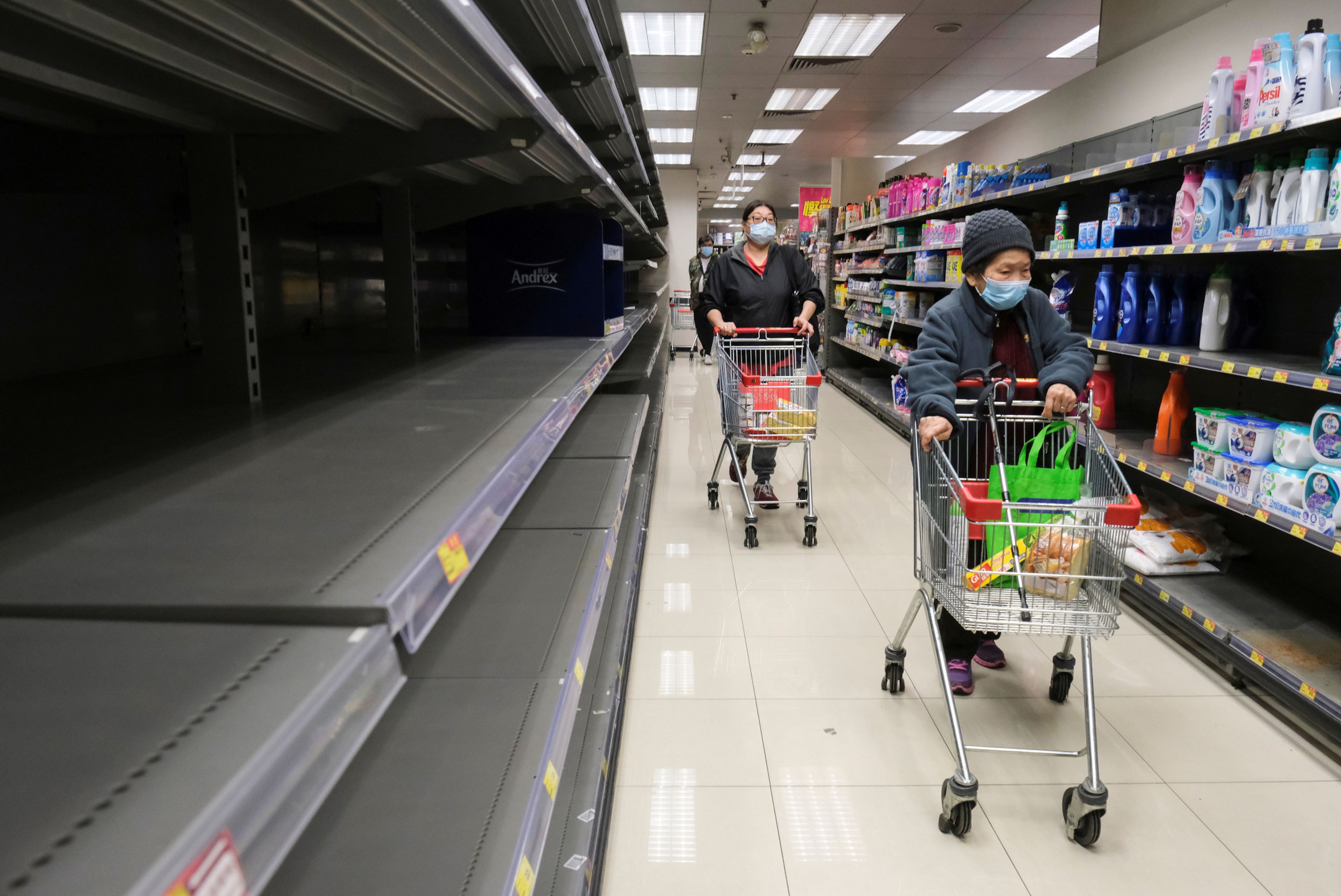 Clientes ante estantes vacíos de papel higiénico en un supermercado en Hong Kong, China, el 6 de febrero de 2020.