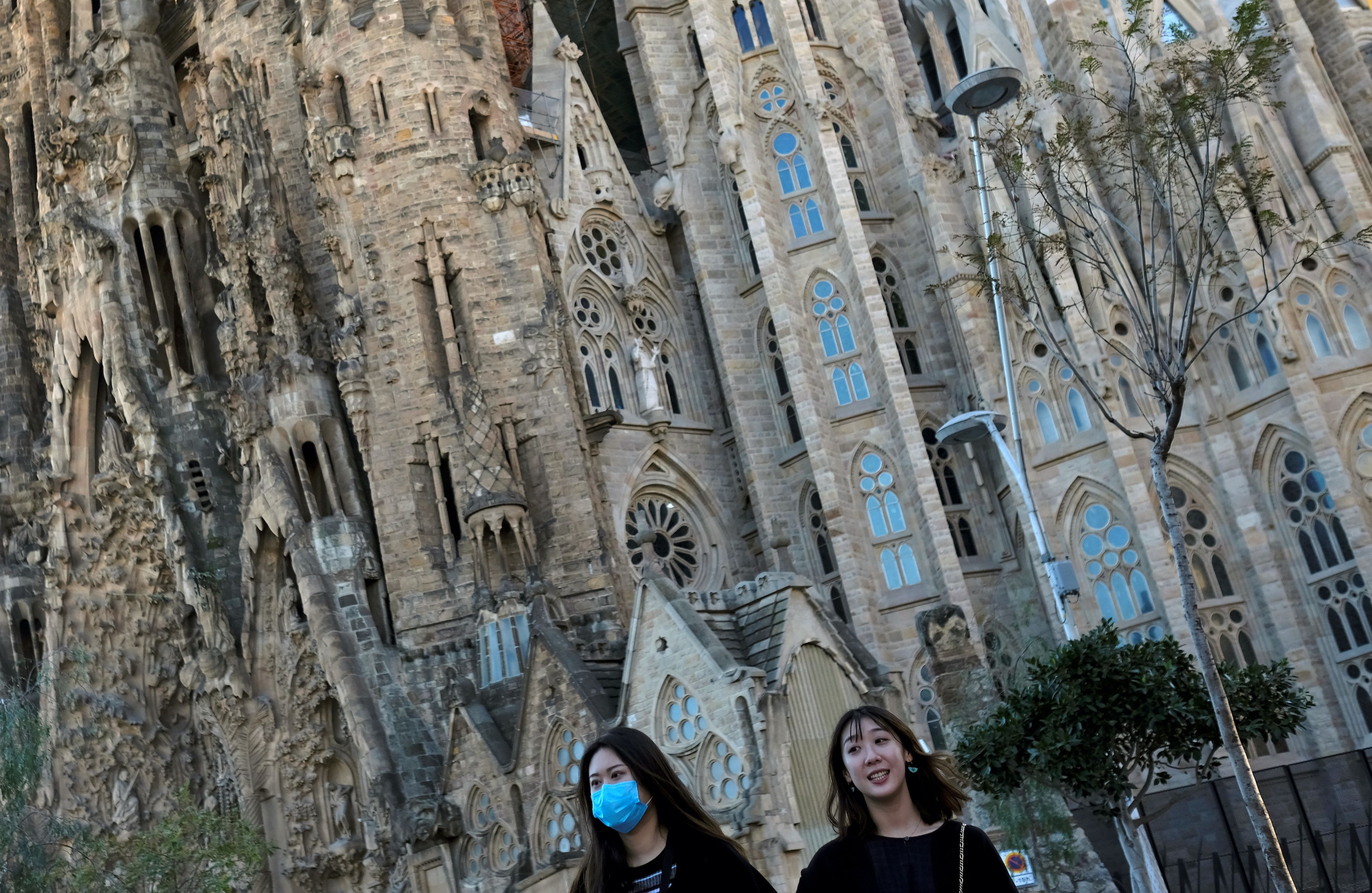 Una mujer lleva una mascarilla junto a la Sagrada Familia de Barcelona.