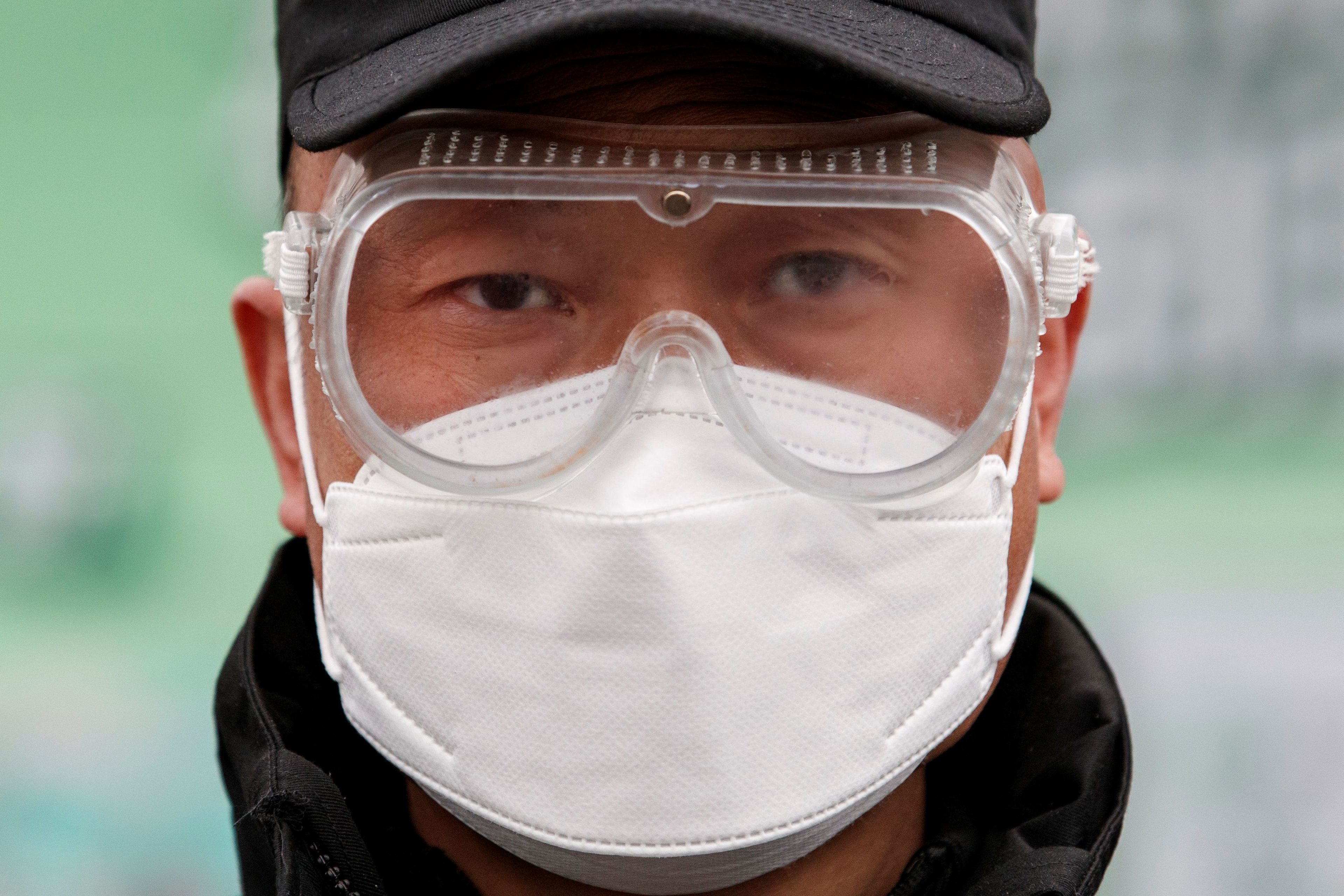 Coronavirus: Un trabajador de una fábrica en Pekín se protege con una mascarilla