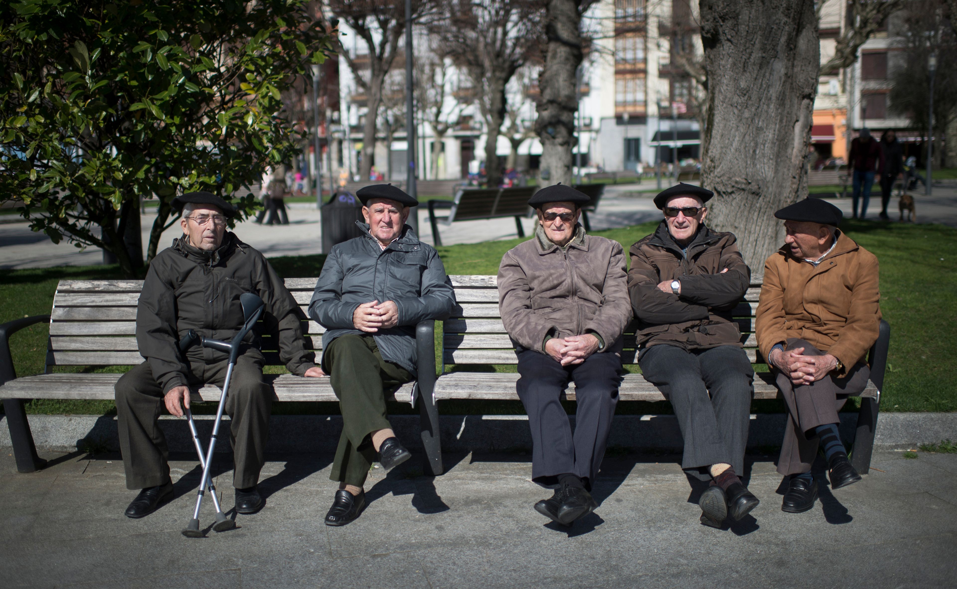 Un grupo de jubilados toma el sol en un banco de Bermeo