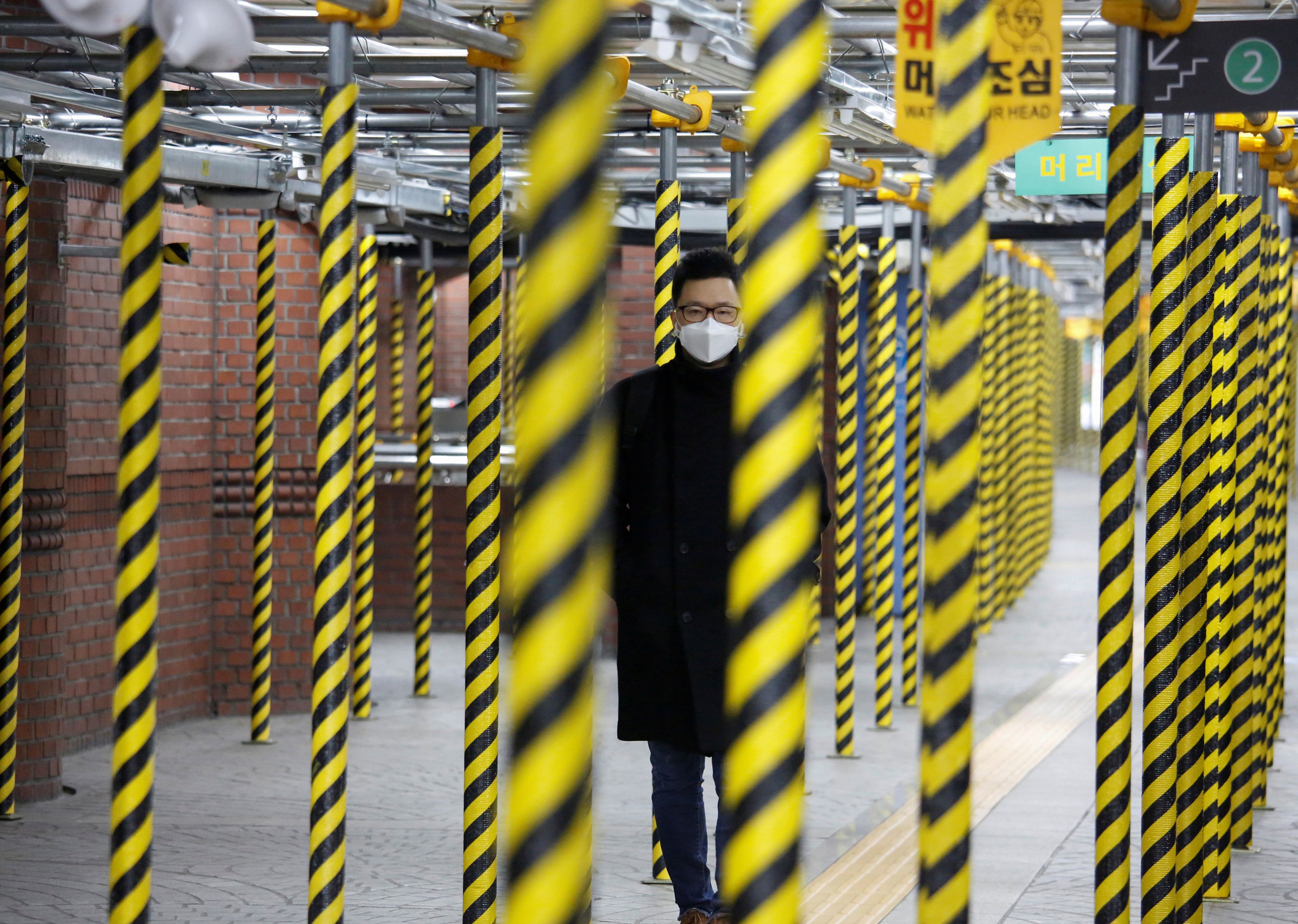 Un hombre camina por el metro de Seúl con una mascarilla para protegerse del brote de coronavirus