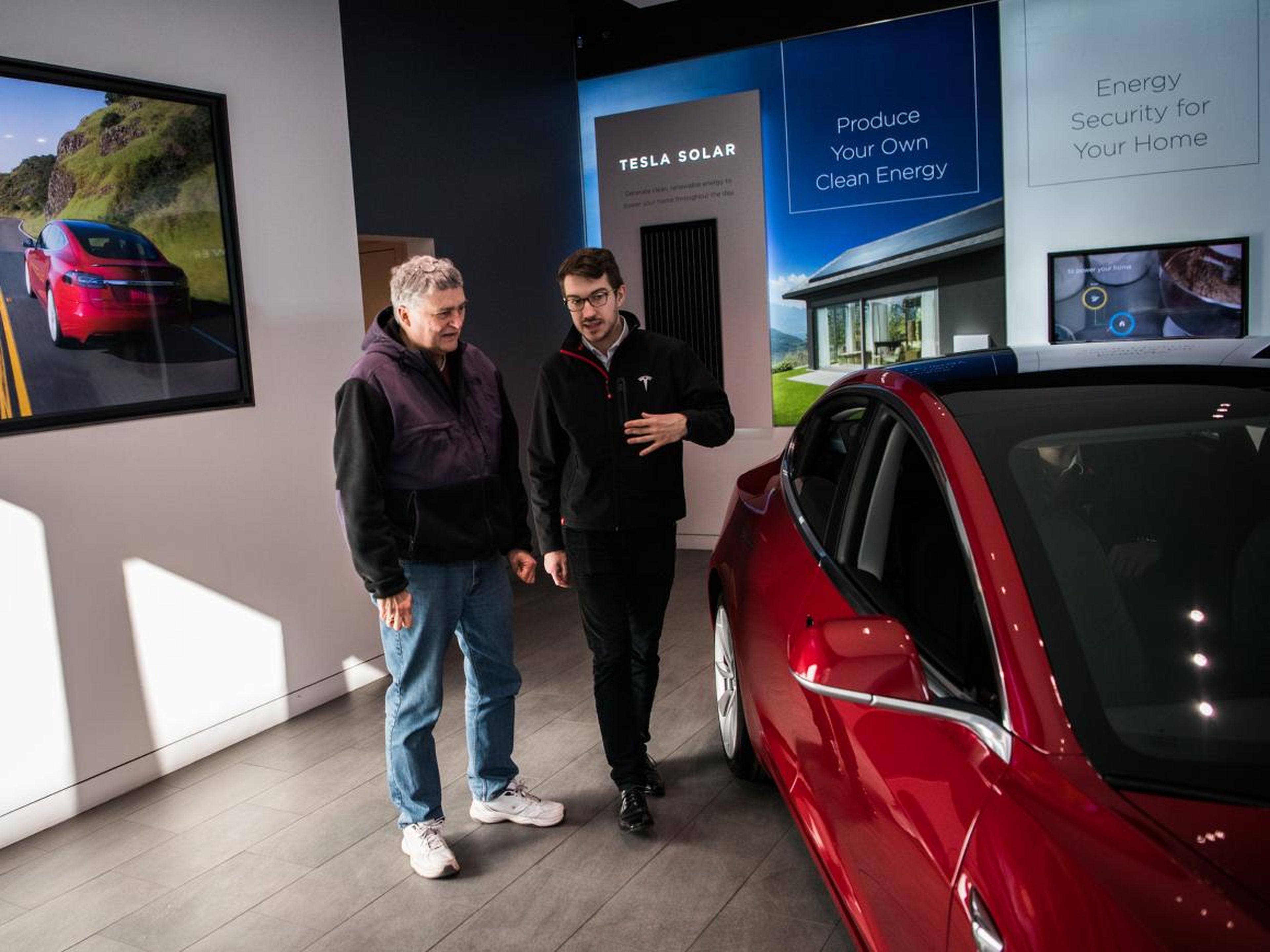 Un empleado de Tesla habla con un cliente potencial.