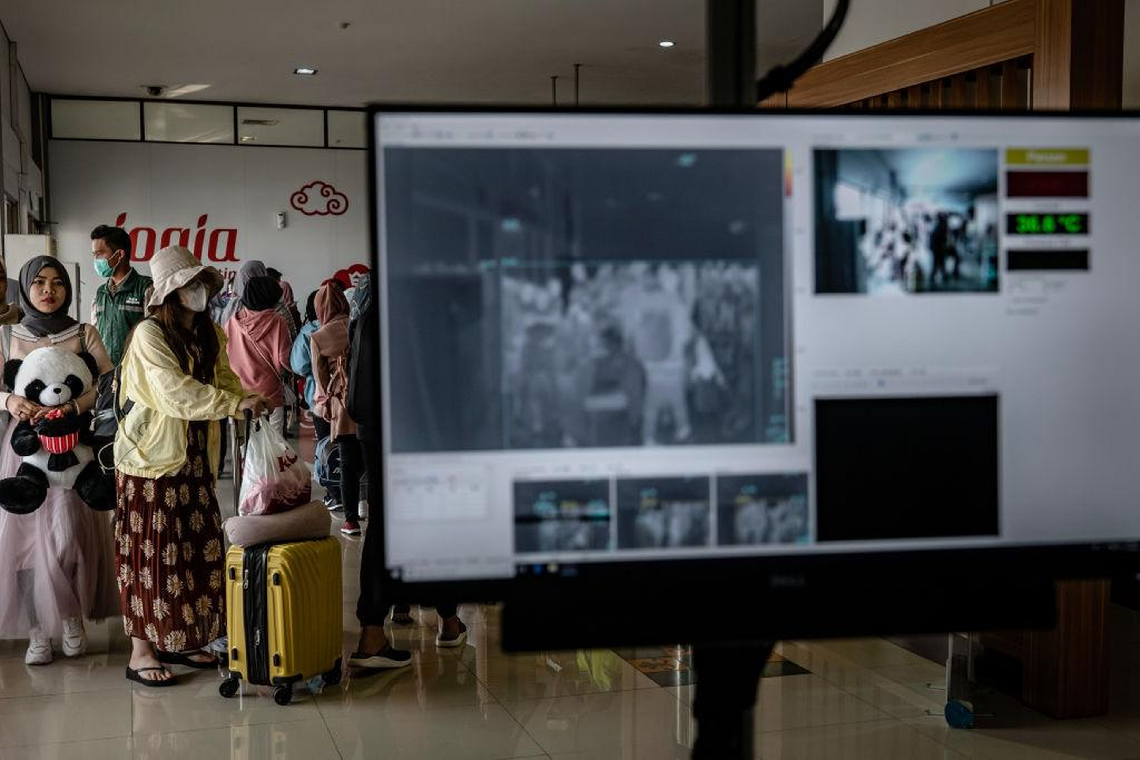 Passengers from an international flight have their temperature checked as they pass a thermal scanner monitor upon arrival at the Adisucipto International Airport on January 23, 2020 in Yogyakarta, Indonesia.