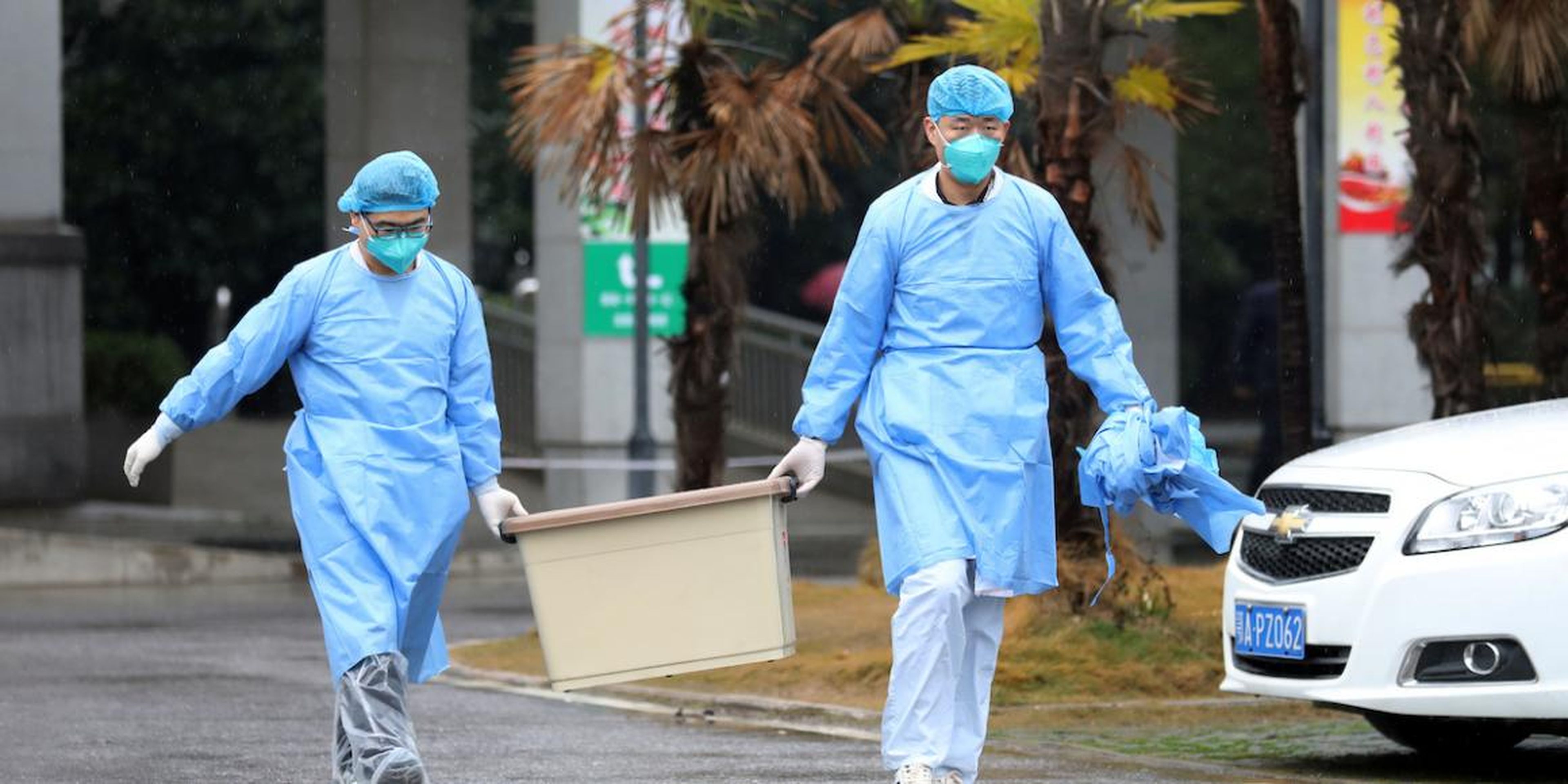 Medical staff carry a box by the Jinyintan hospital in Wuhan, which houses patients with the Wuhan coronavirus, on January 10, 2020.