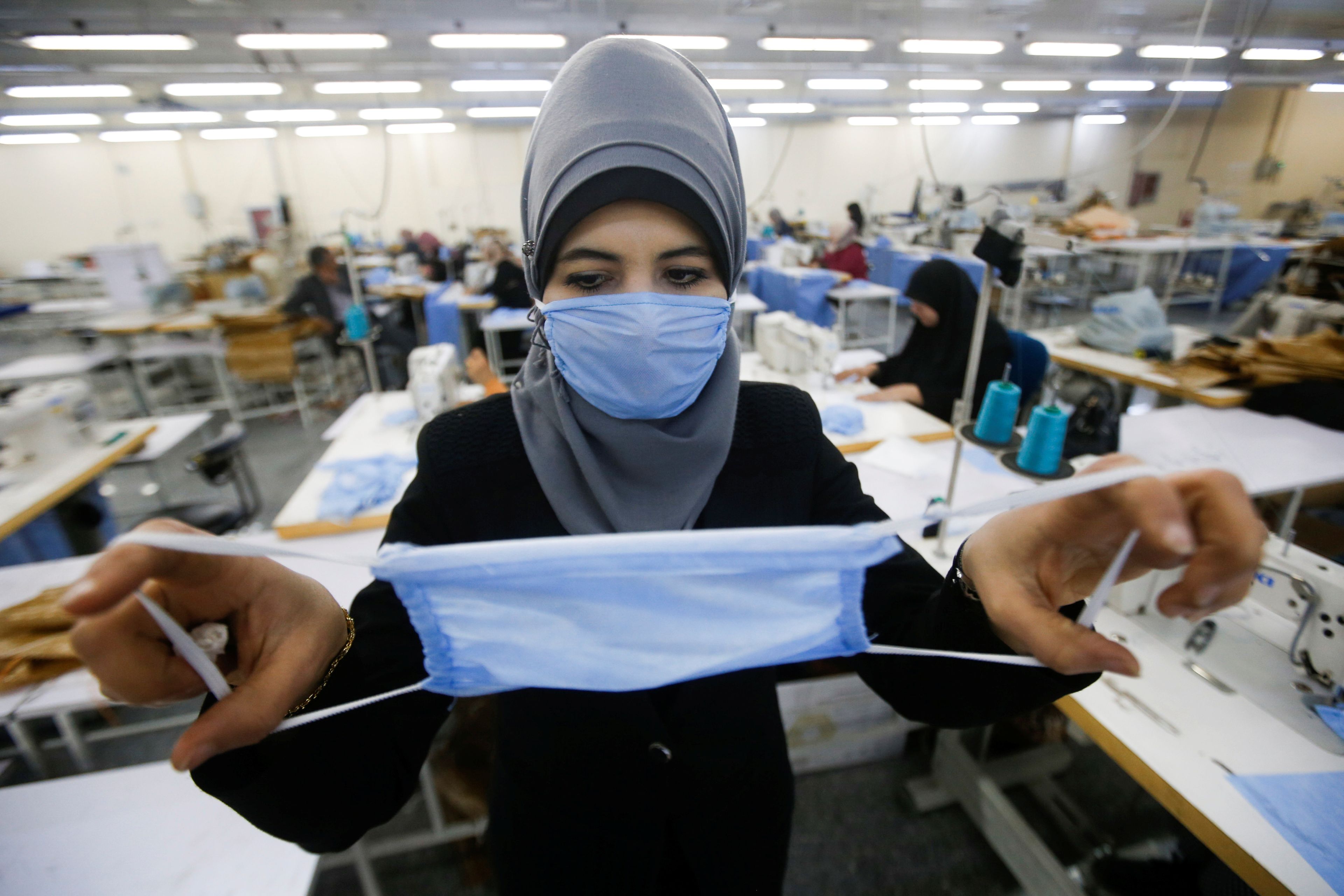 Una mujer en Irán fabricando mascarillas para el coronavirus.