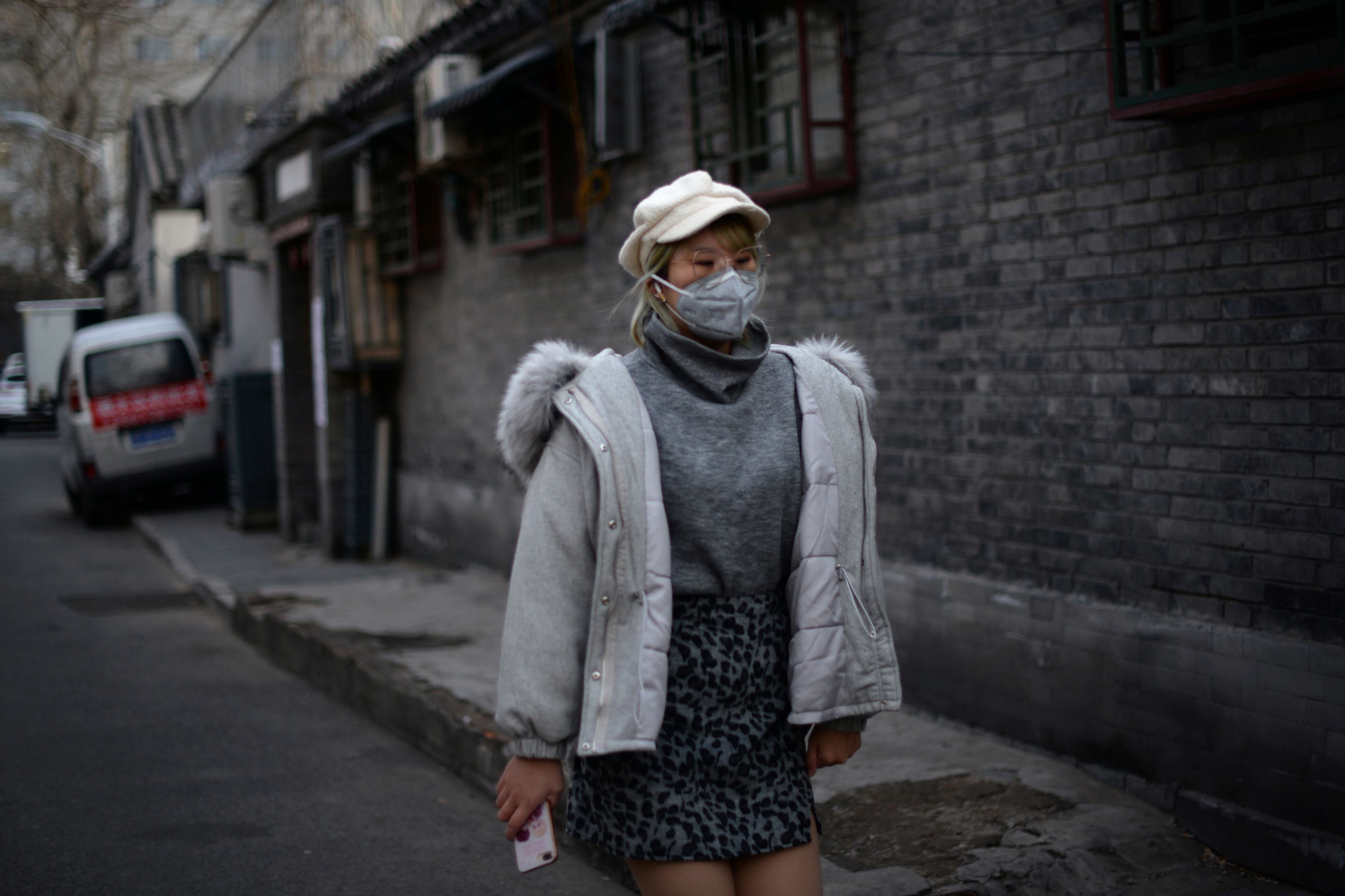 Mujer pasea por las calles de China ante el coronavirus.