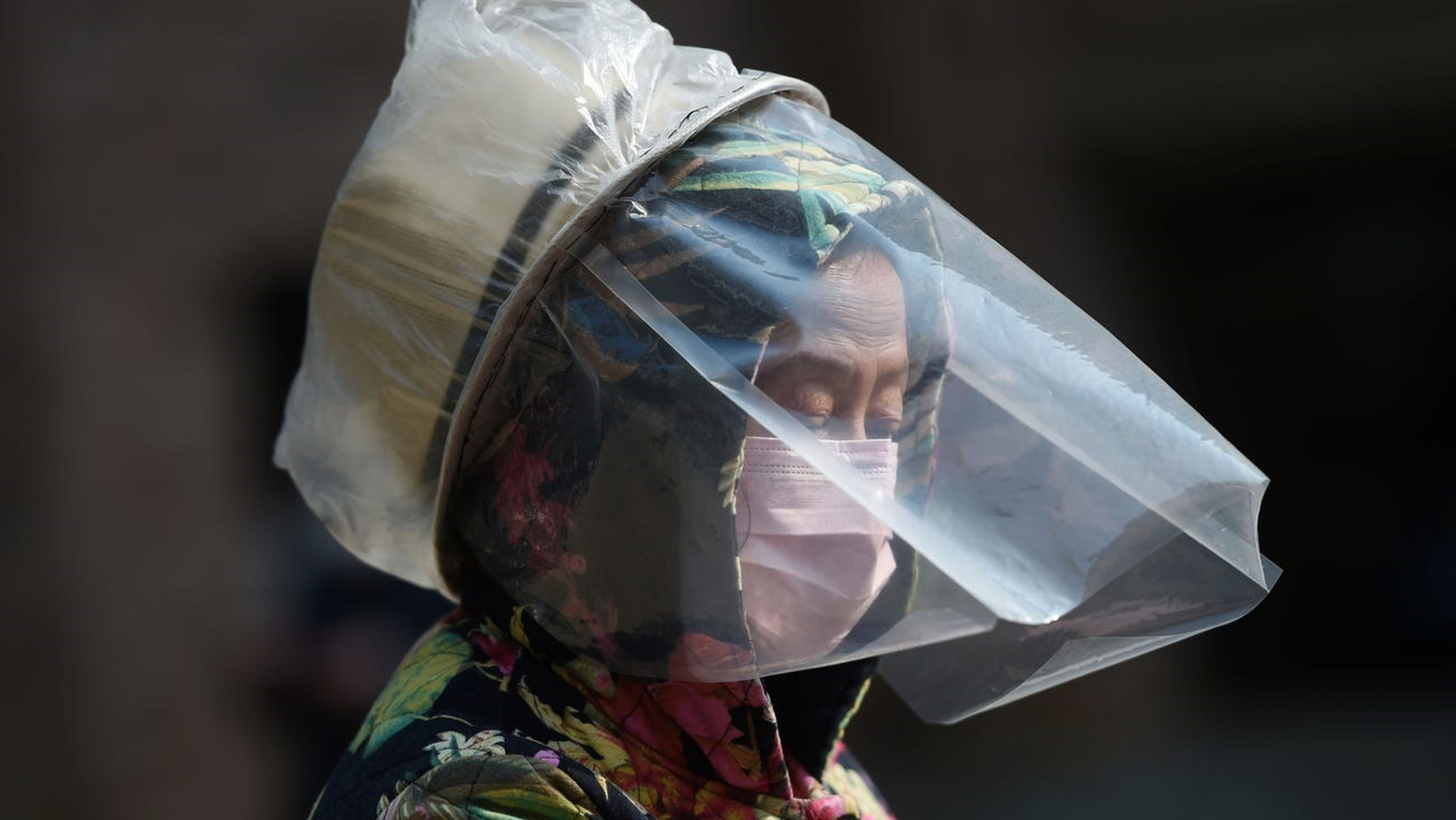 Una mujer se protege la cara con mascarilla en Wuhan, China, epicentro del coronavirus