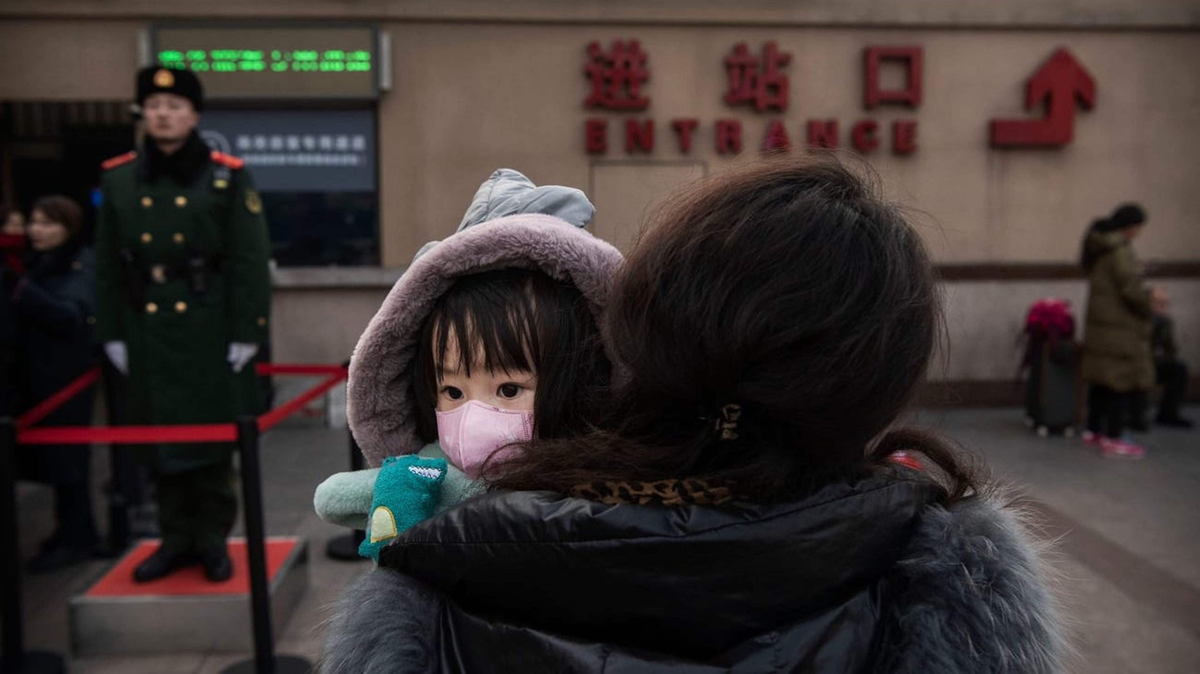 Una niña lleva una máscara en la estación central de trenes de Pekín.