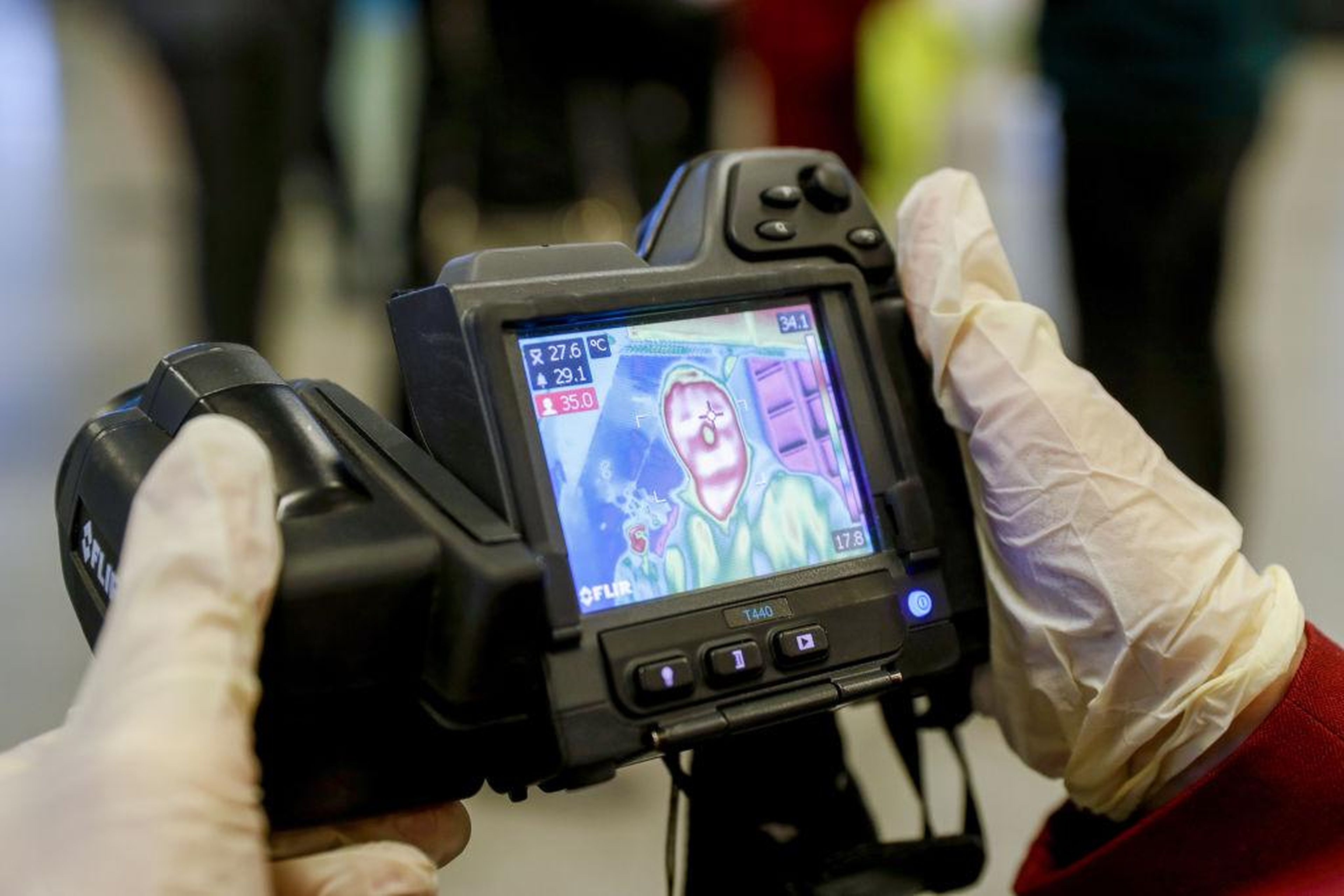 A sanitary and quarantine control official screens the temperatures of arriving passengers at Vnukovo International Airport; temperature screening using thermal imaging devices is under way at Vnukovo Airport