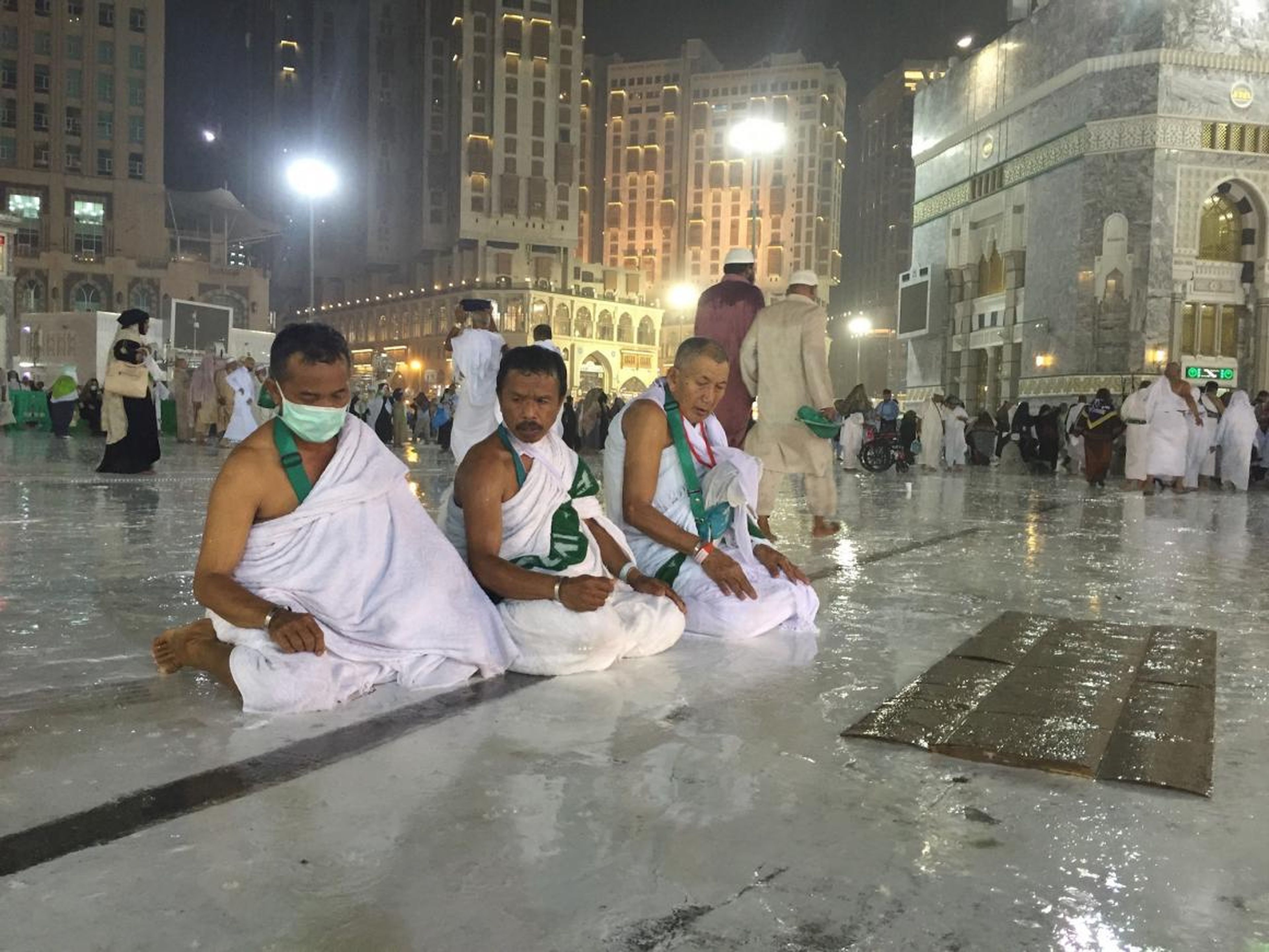 Gente rezando bajo la lluvia.