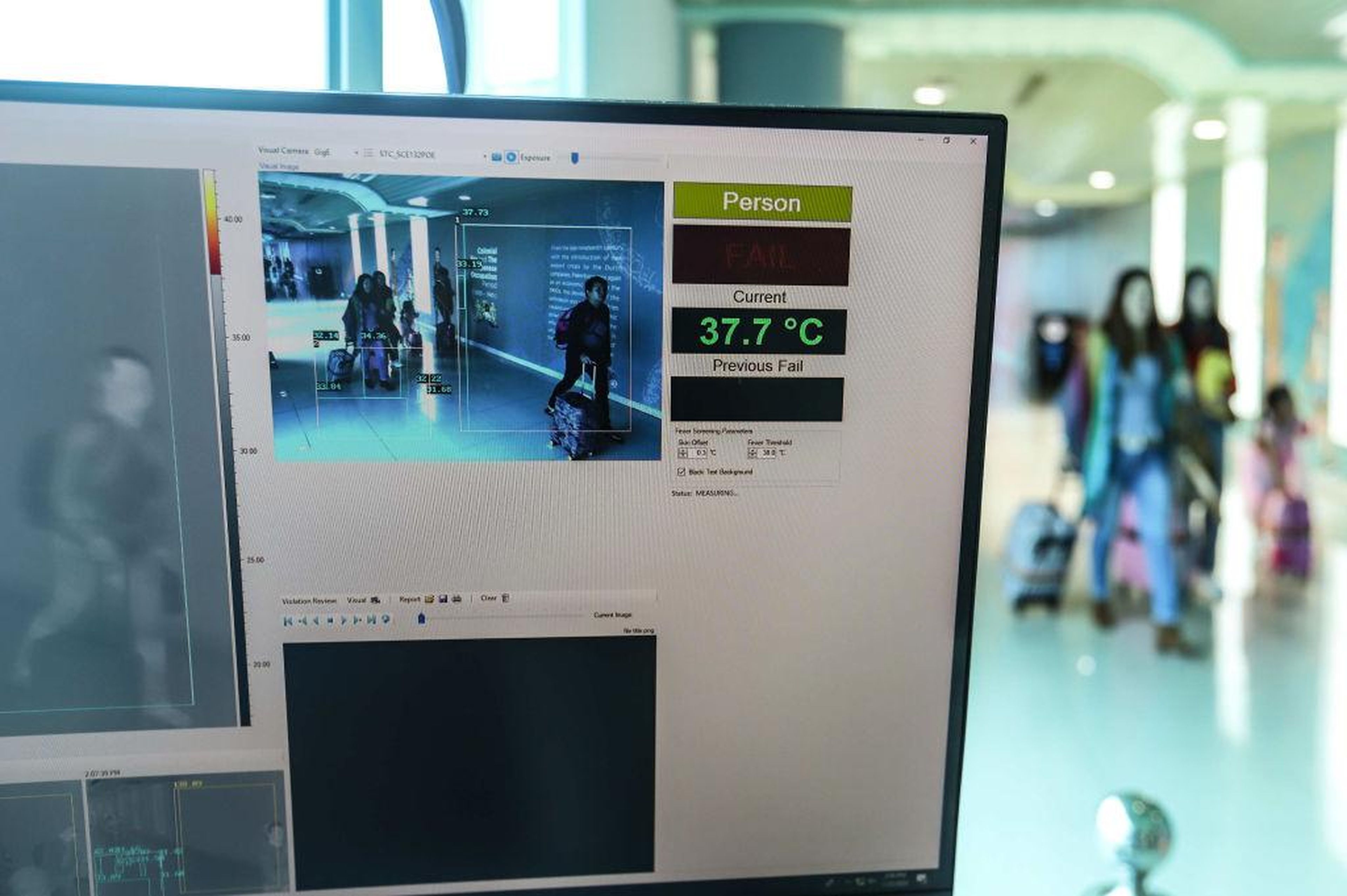 Passengers walk through a thermal scanner upon their arrival at Sultan Mahmud Badaruddin II International airport in Palembang, Indonesia on January 23, 2020.