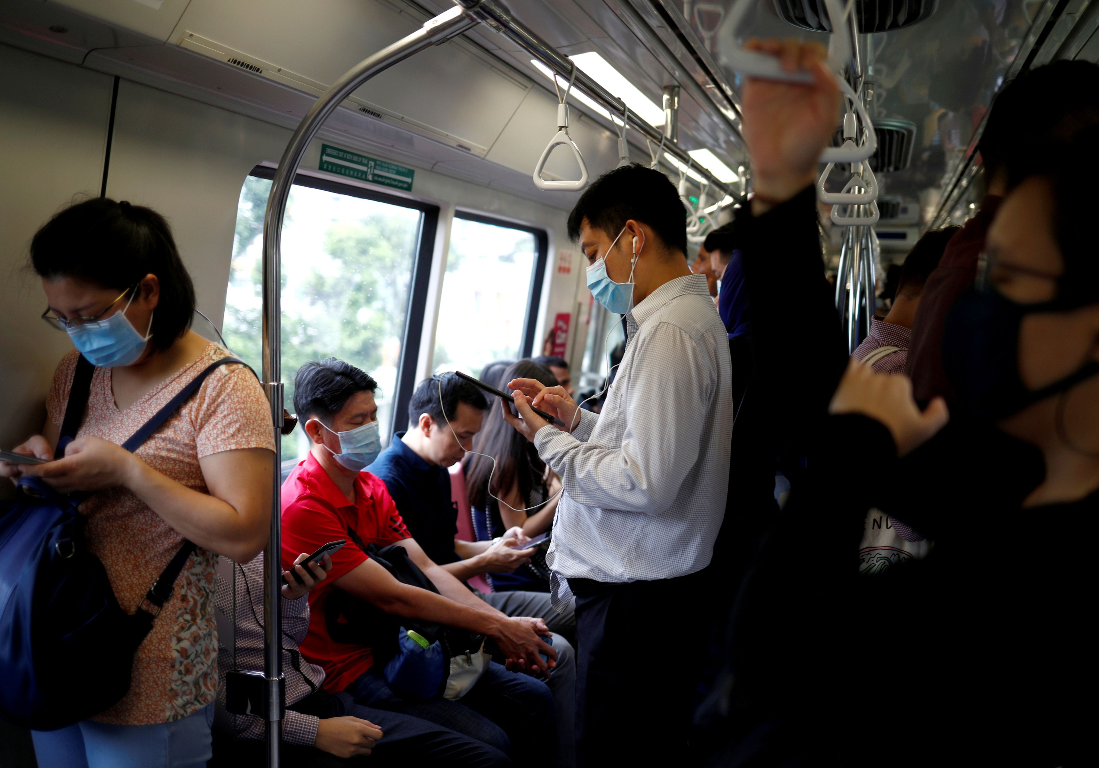 Personas en un autobús de Singapur ante el miedo del coronavirus.